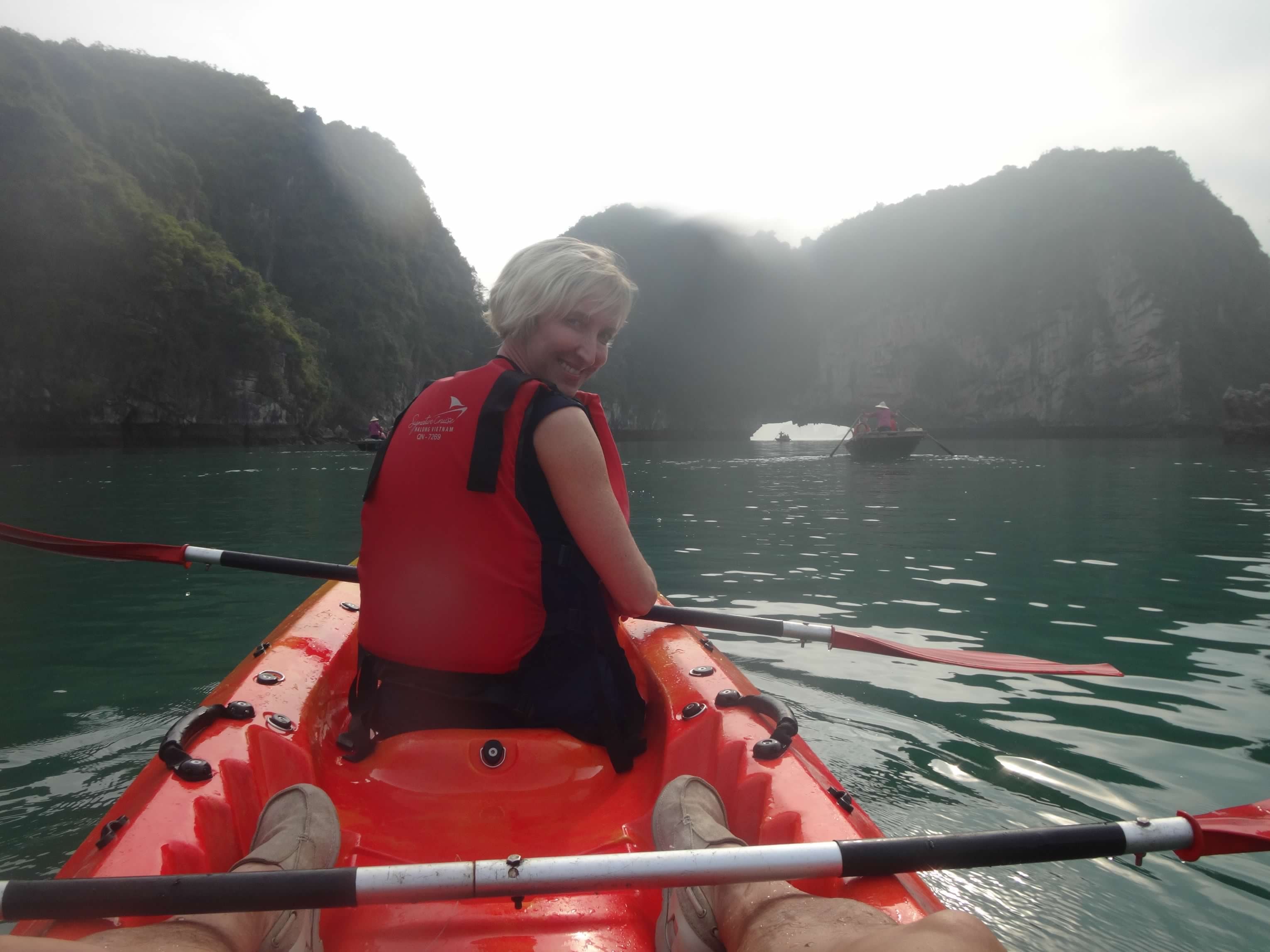 Advisor in a kayak on a beautiful lake surrounded by cliffs