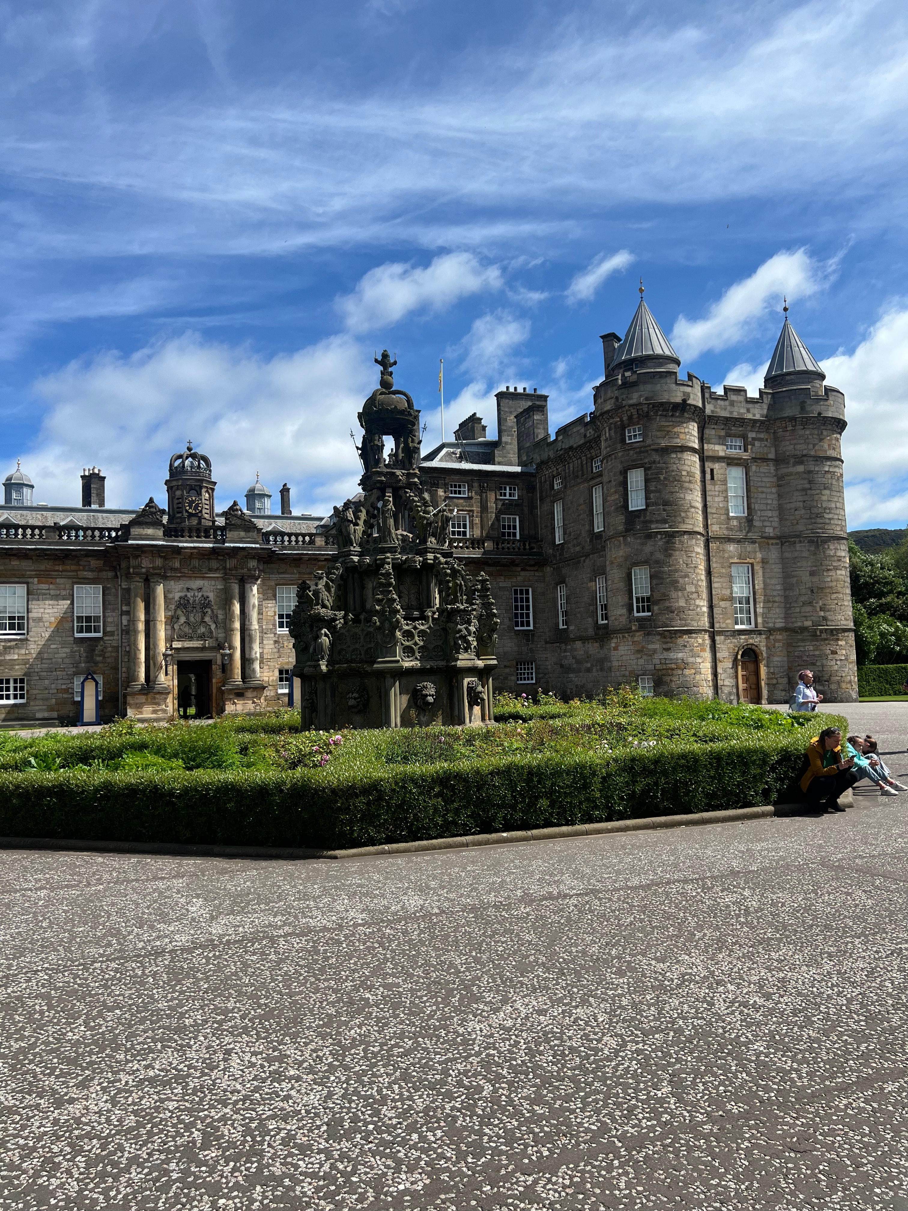 View of an old castle-like building with statue out front on a sunny day