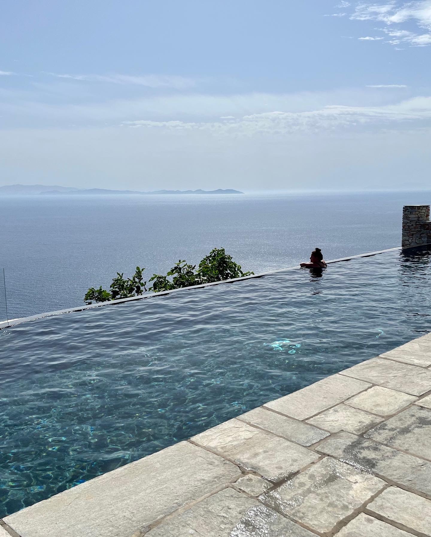 Advisor leaning over the edge of a small rooftop infinity pool overlooking the sea