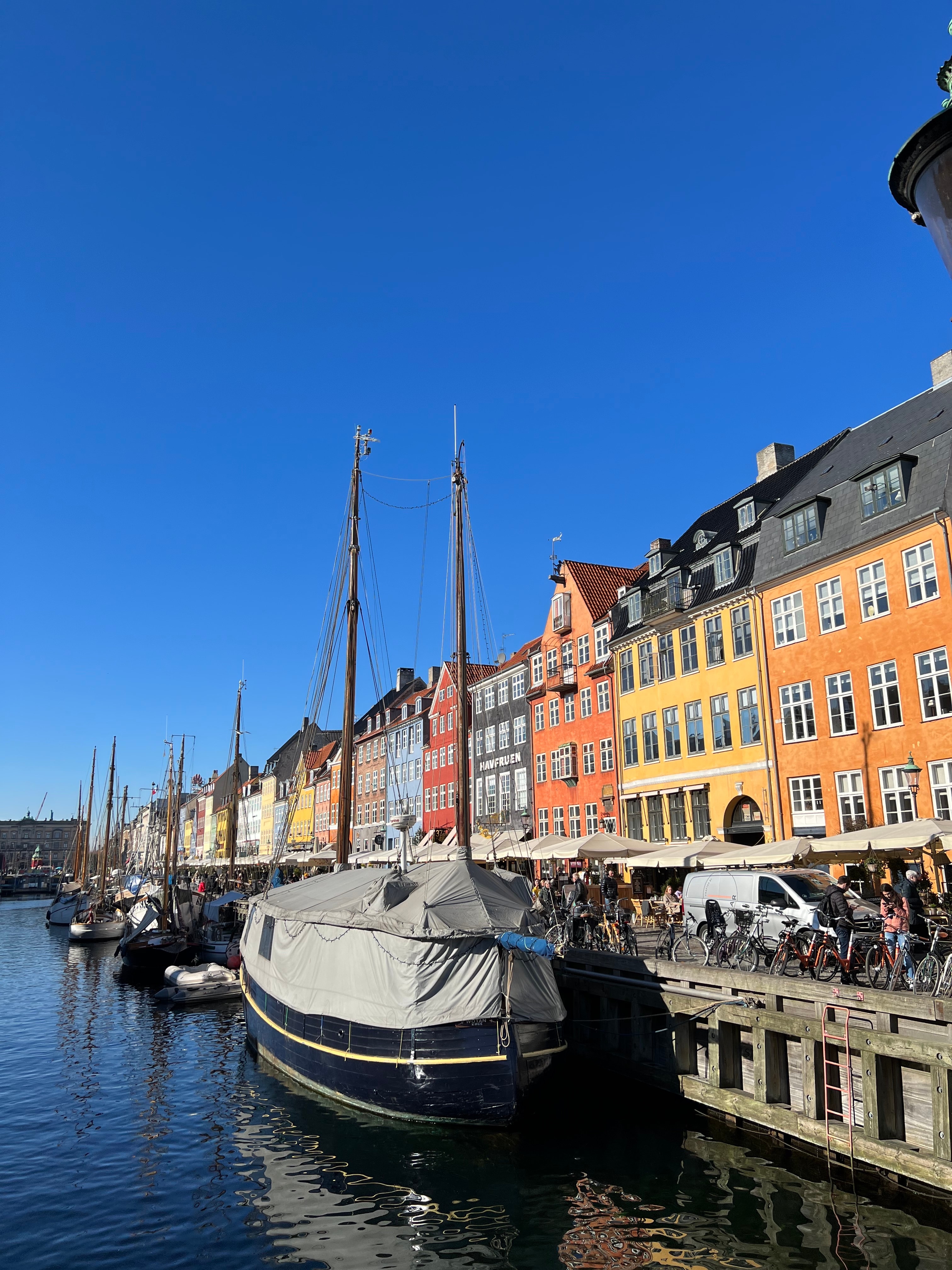 Colorful buildings and sailboats along the harbor in Copenhagen on a clear day