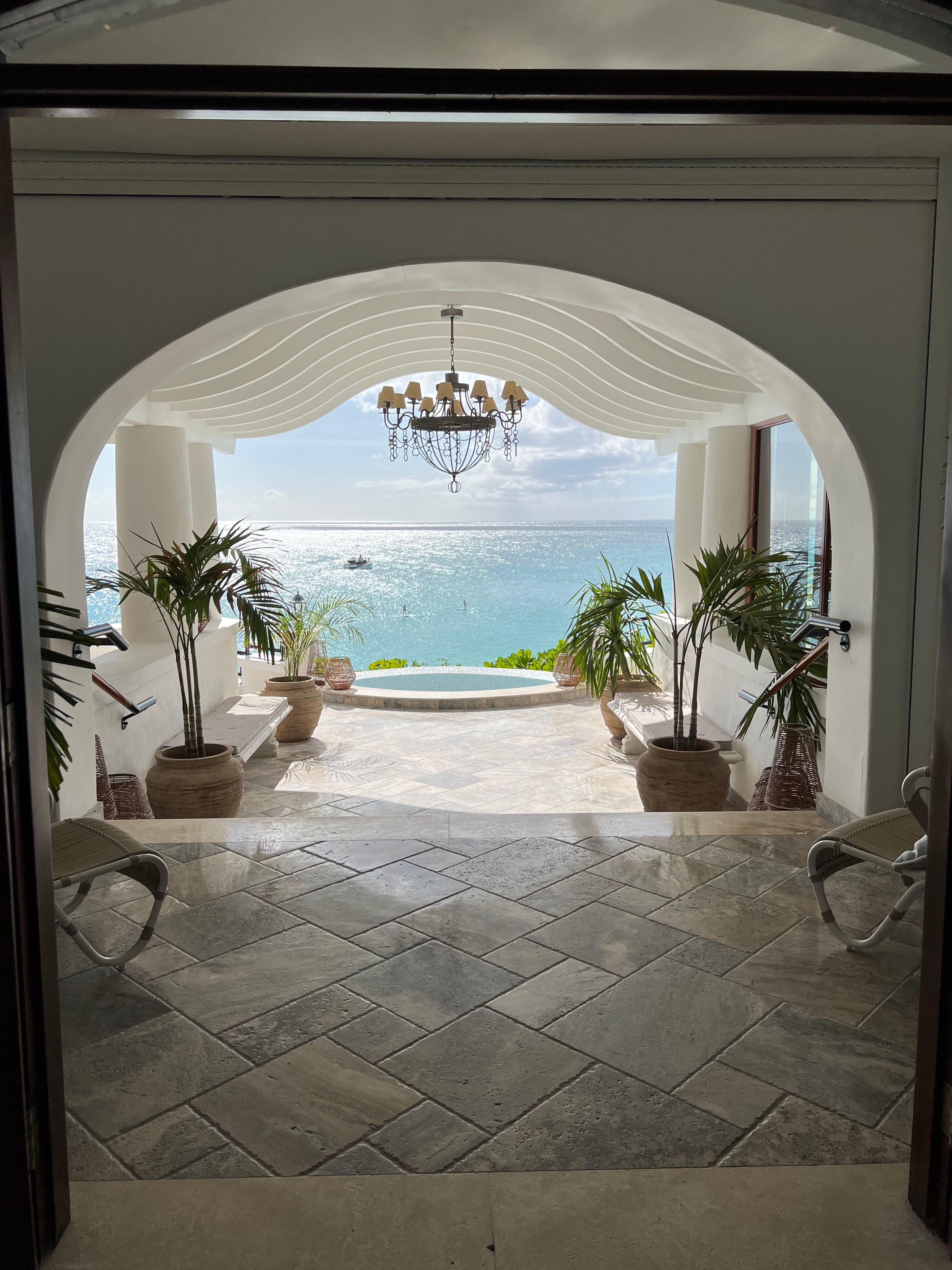 View of the front steps of a resort lobby in St. Martin with the ocean shining in the distance