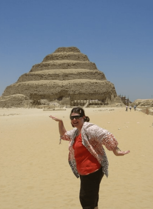 Advisor posing like an ancient Egyptian in front of a tiered pyramid on a clear day