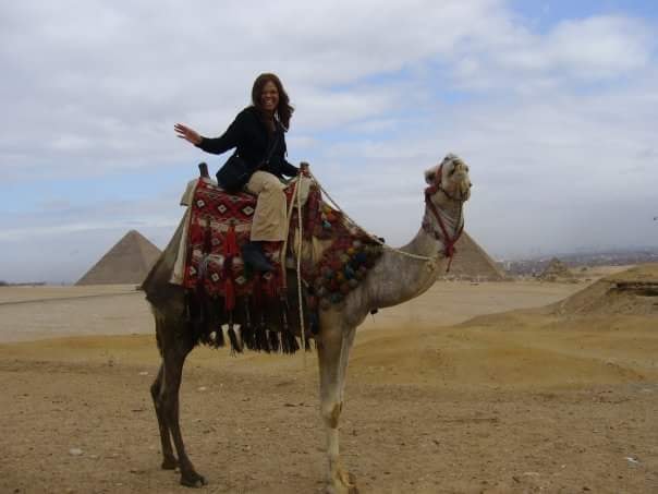 Advisor on a camel’s back with the Giza Pyramids in the background