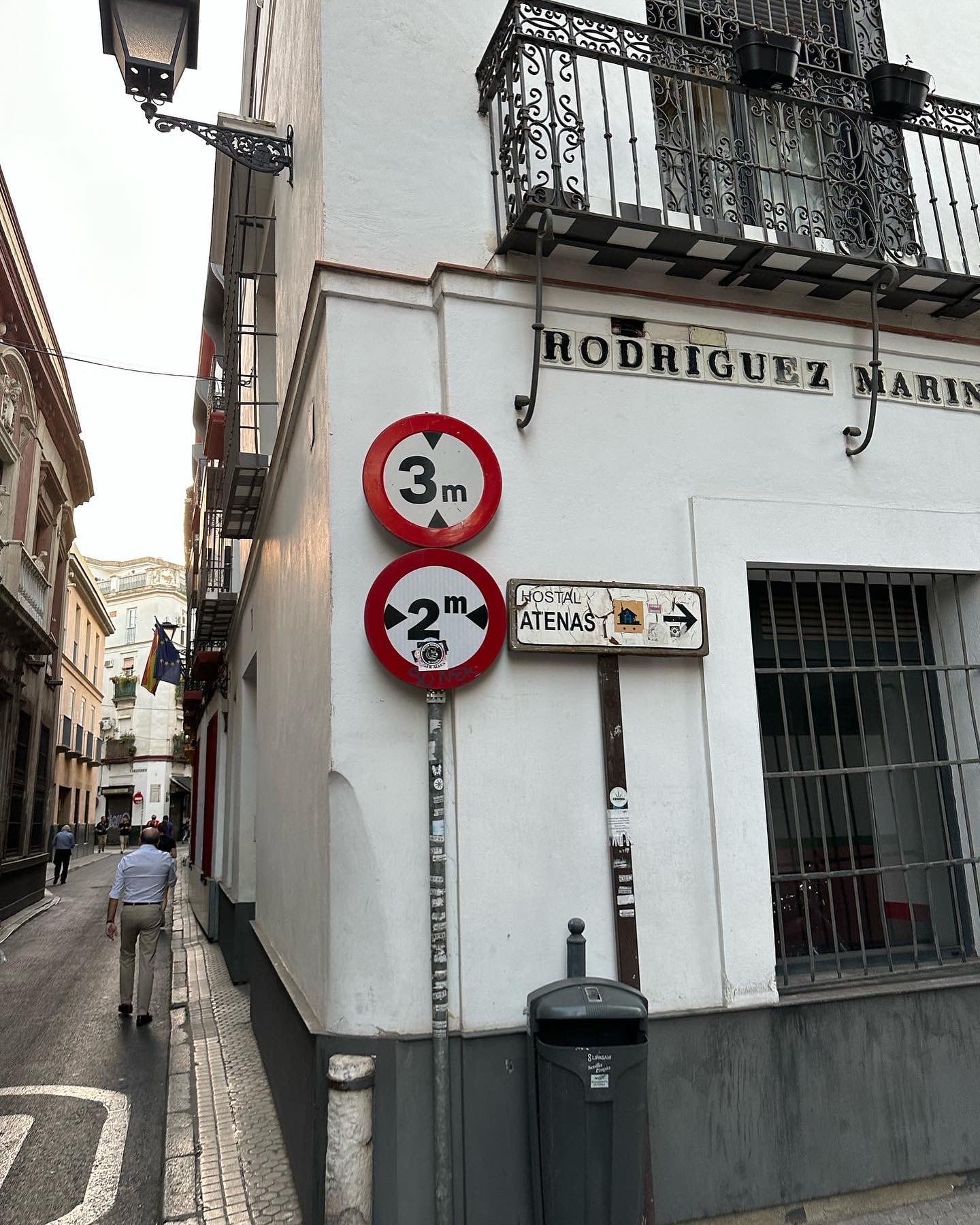 A view of signs for directions on a white building in a city during the daytime. 