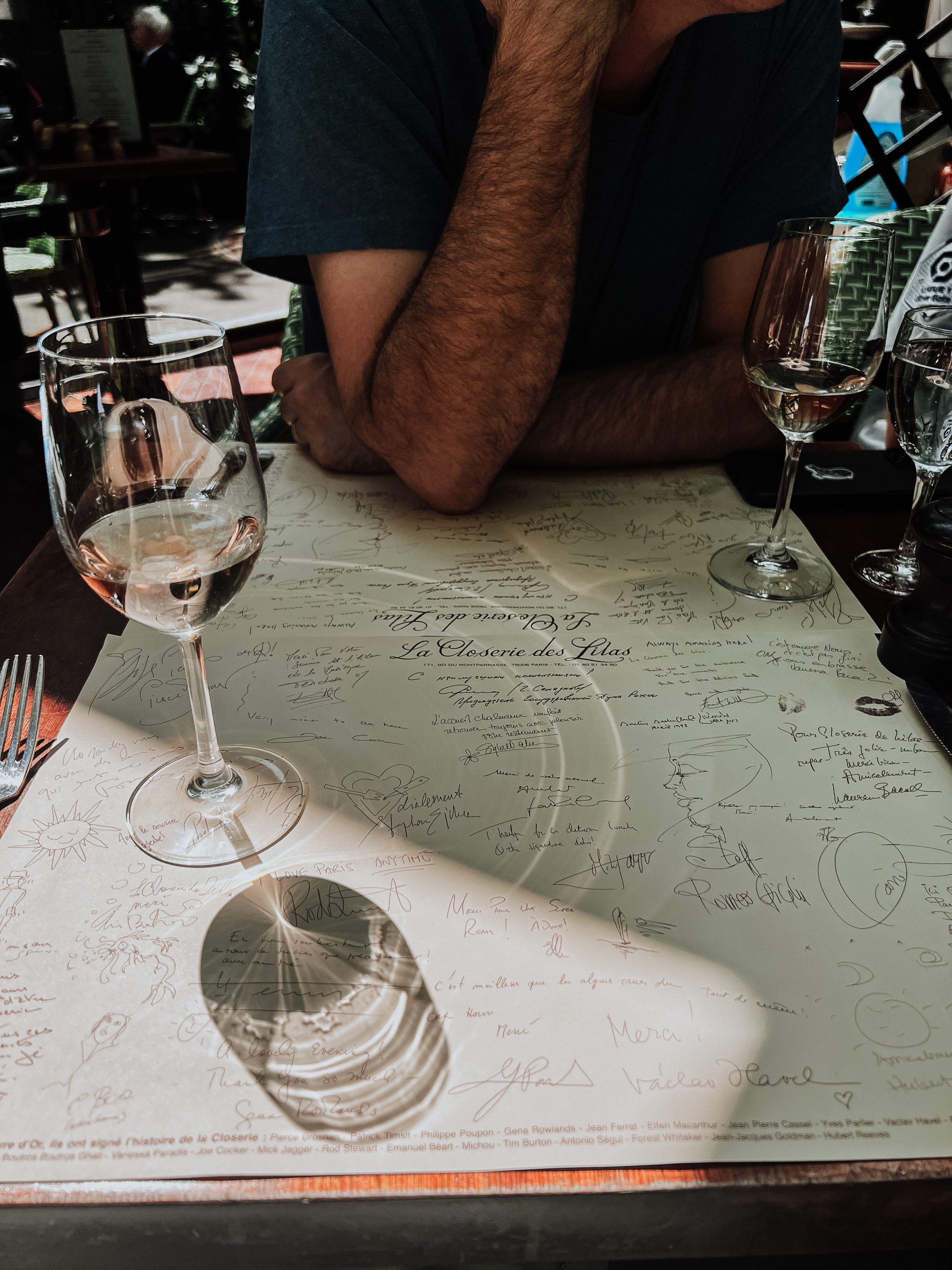 View of a restaurant table with a wine glass reflecting in sunlight