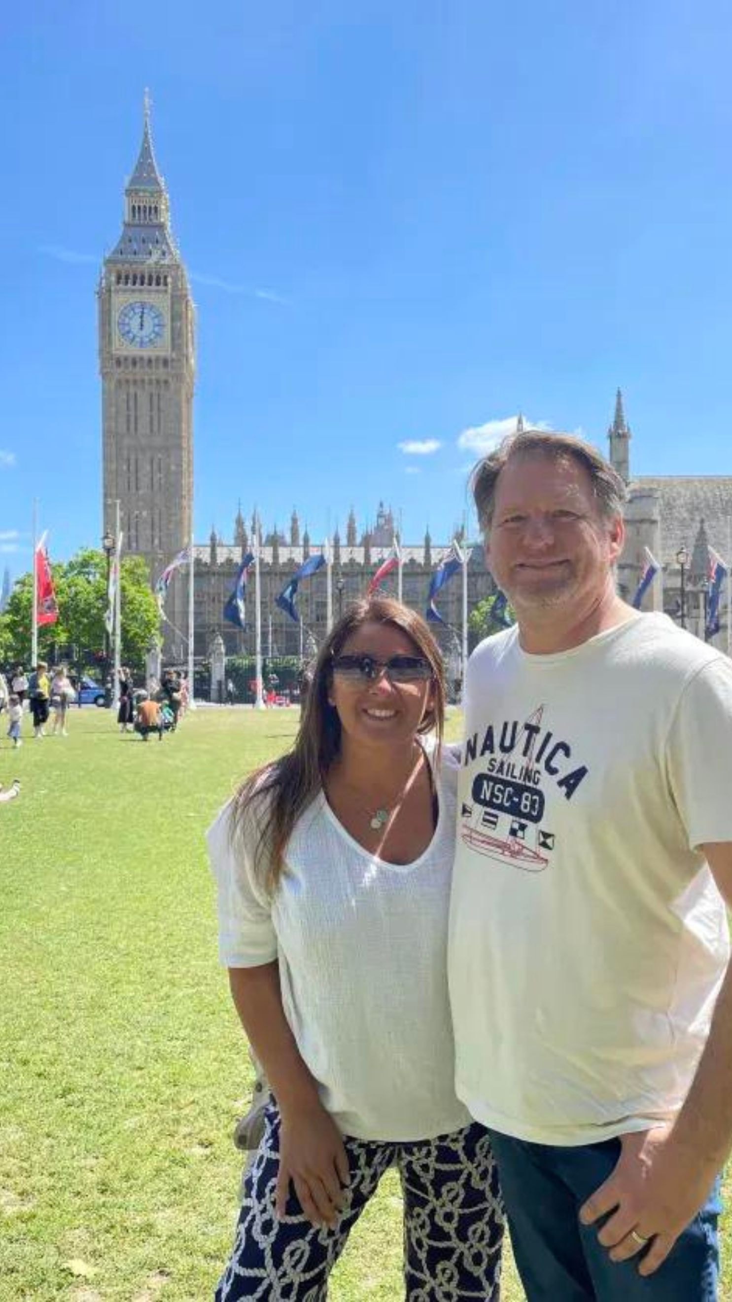 Advisor and partner smiling side by side with Big Ben in the background on a clear day in London