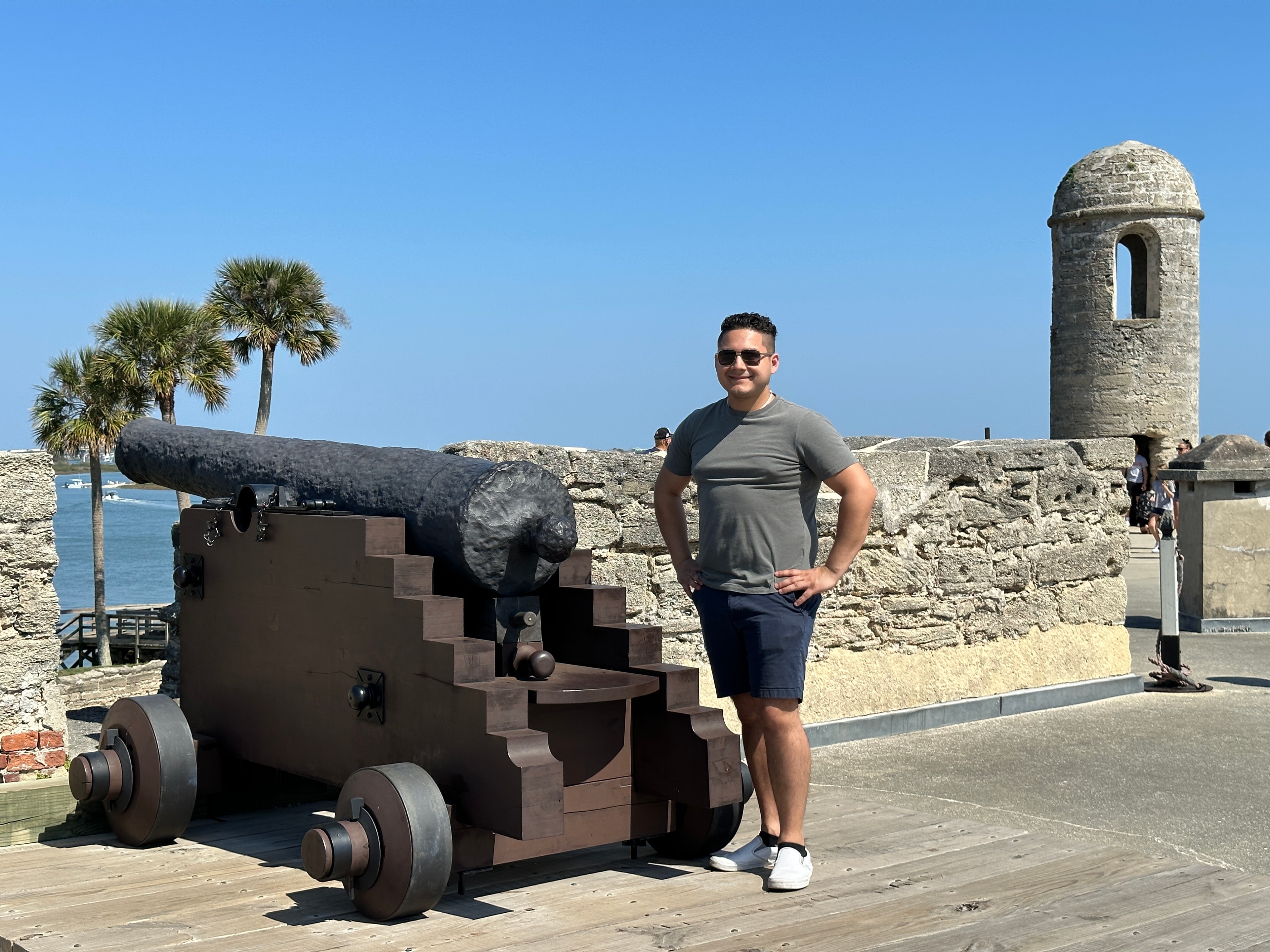 Advisor posing next to a cannon during the daytime. 