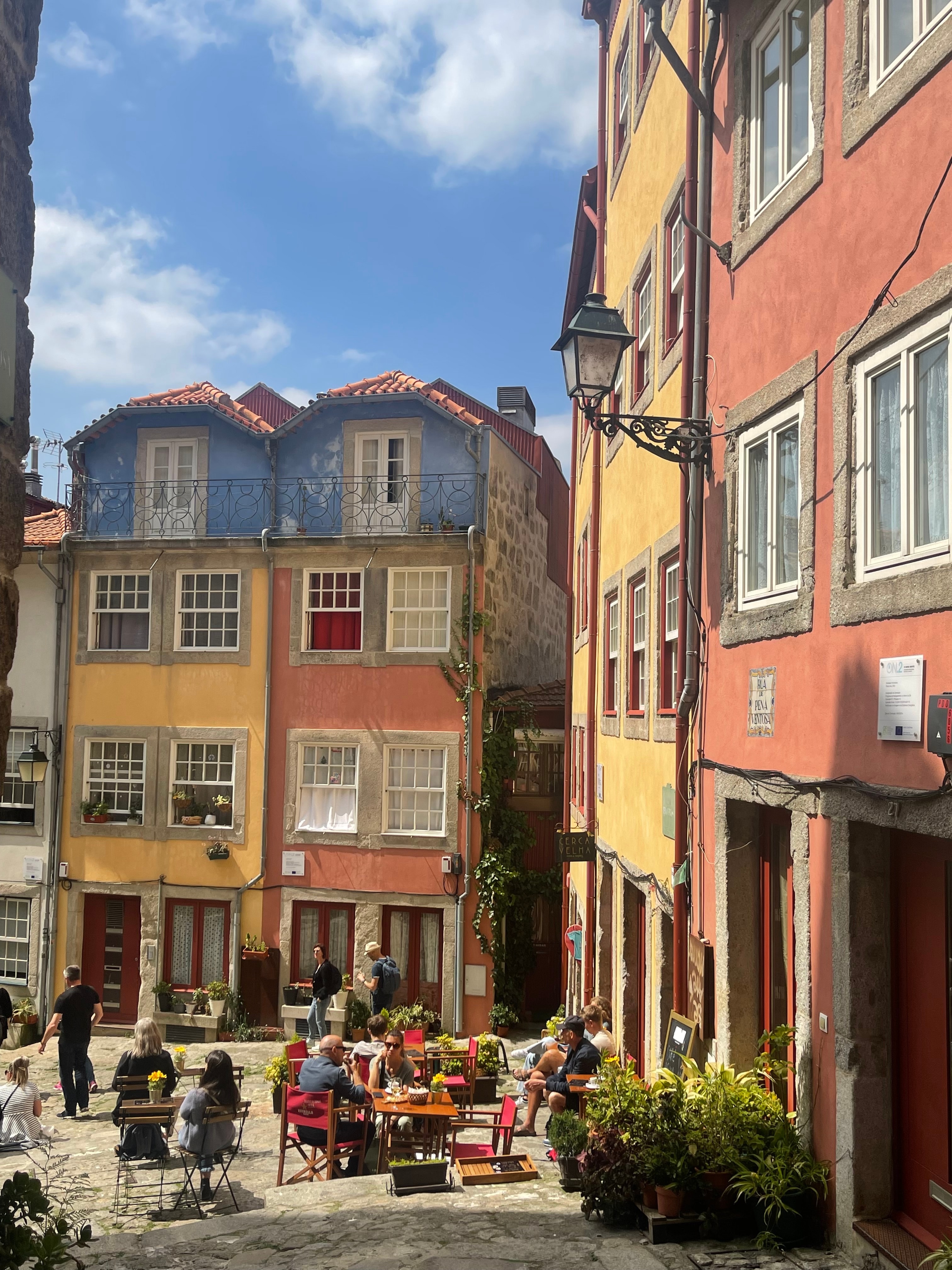 Courtyard with outdoor seating in a small city with yellow and red buildings on a sunny day