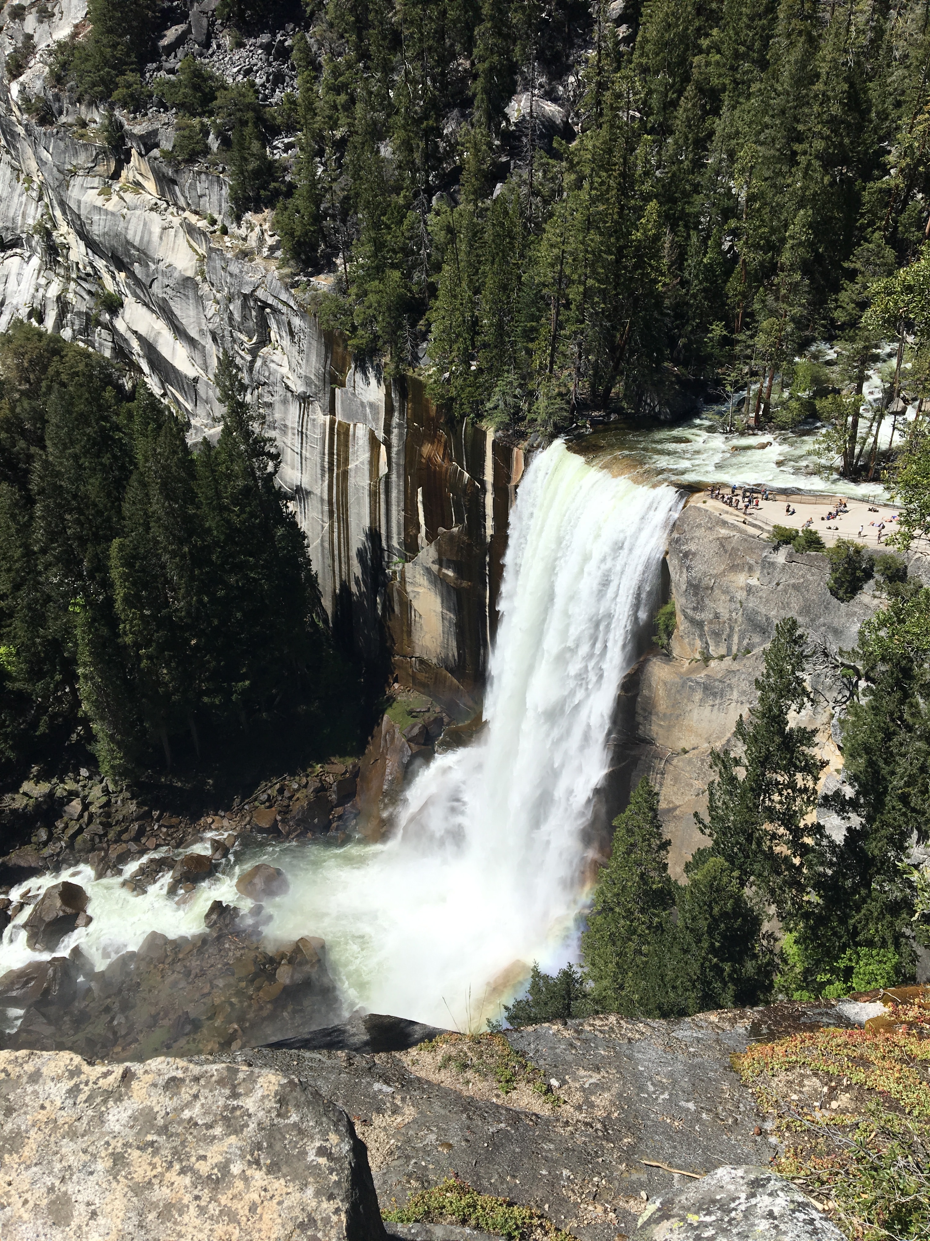 View of a large waterfall pouring from rocky cliffs in the forest