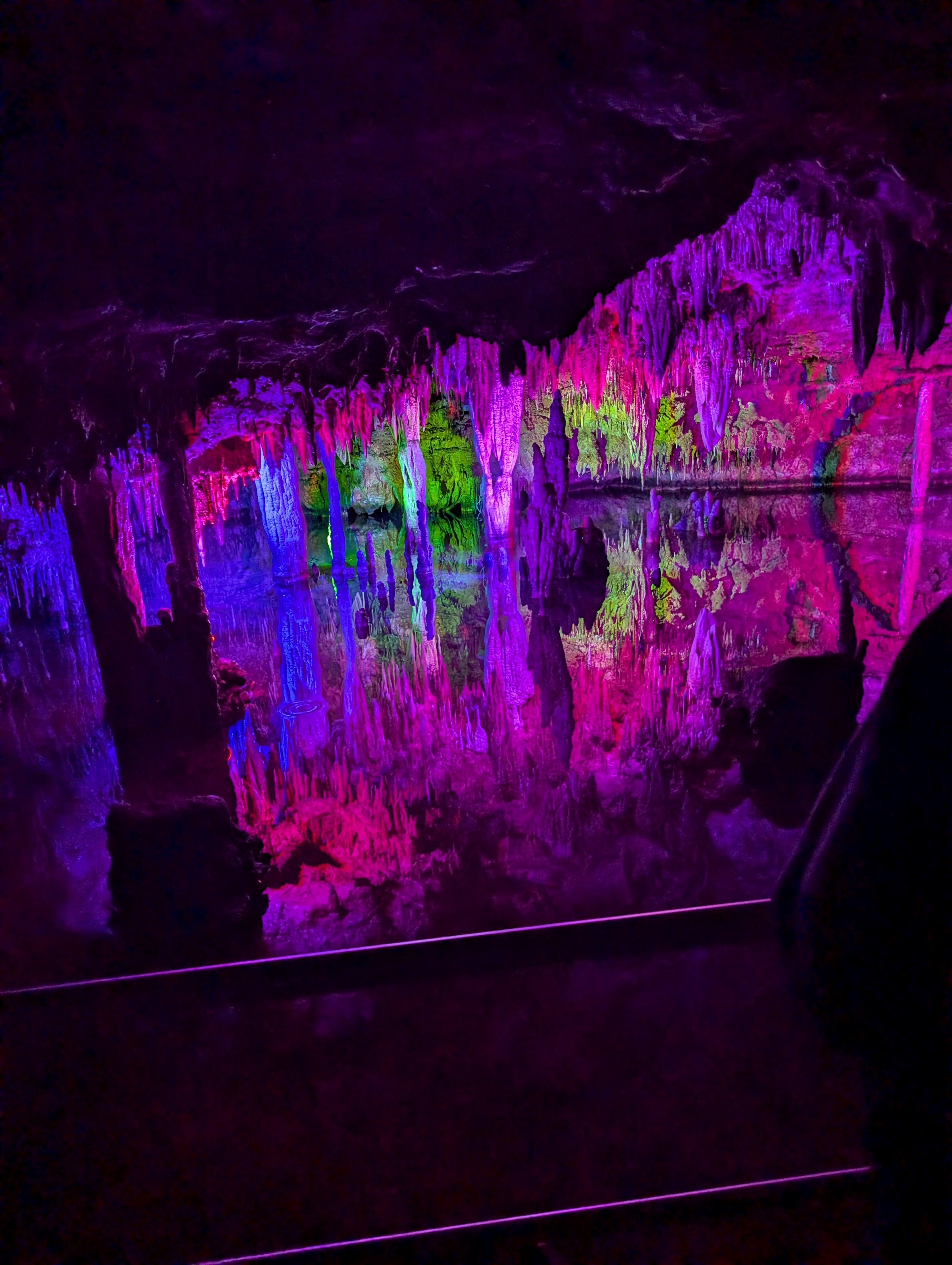 View of a cave interior lit up by purple lights