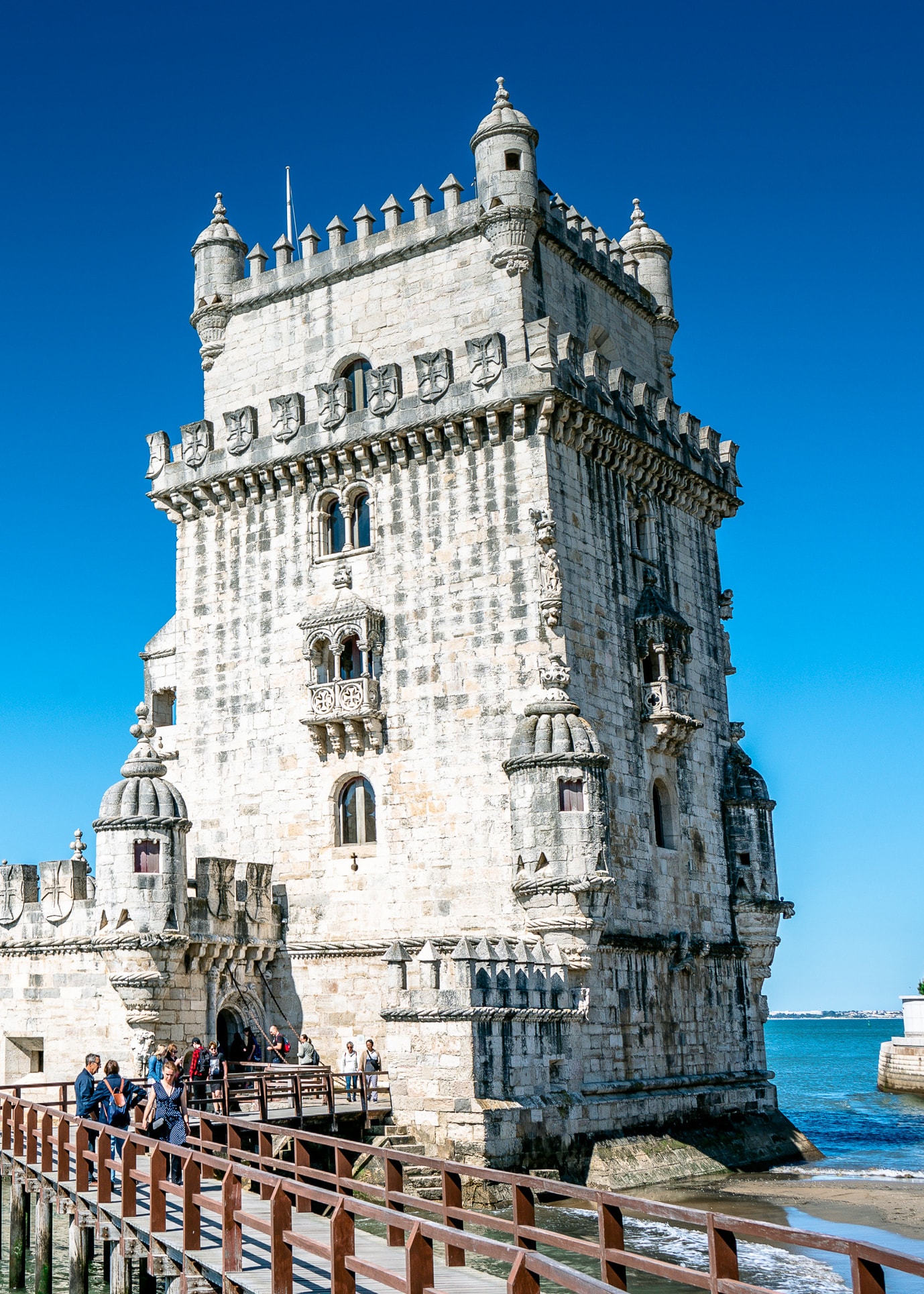 View of a large white square stone tower by the sea