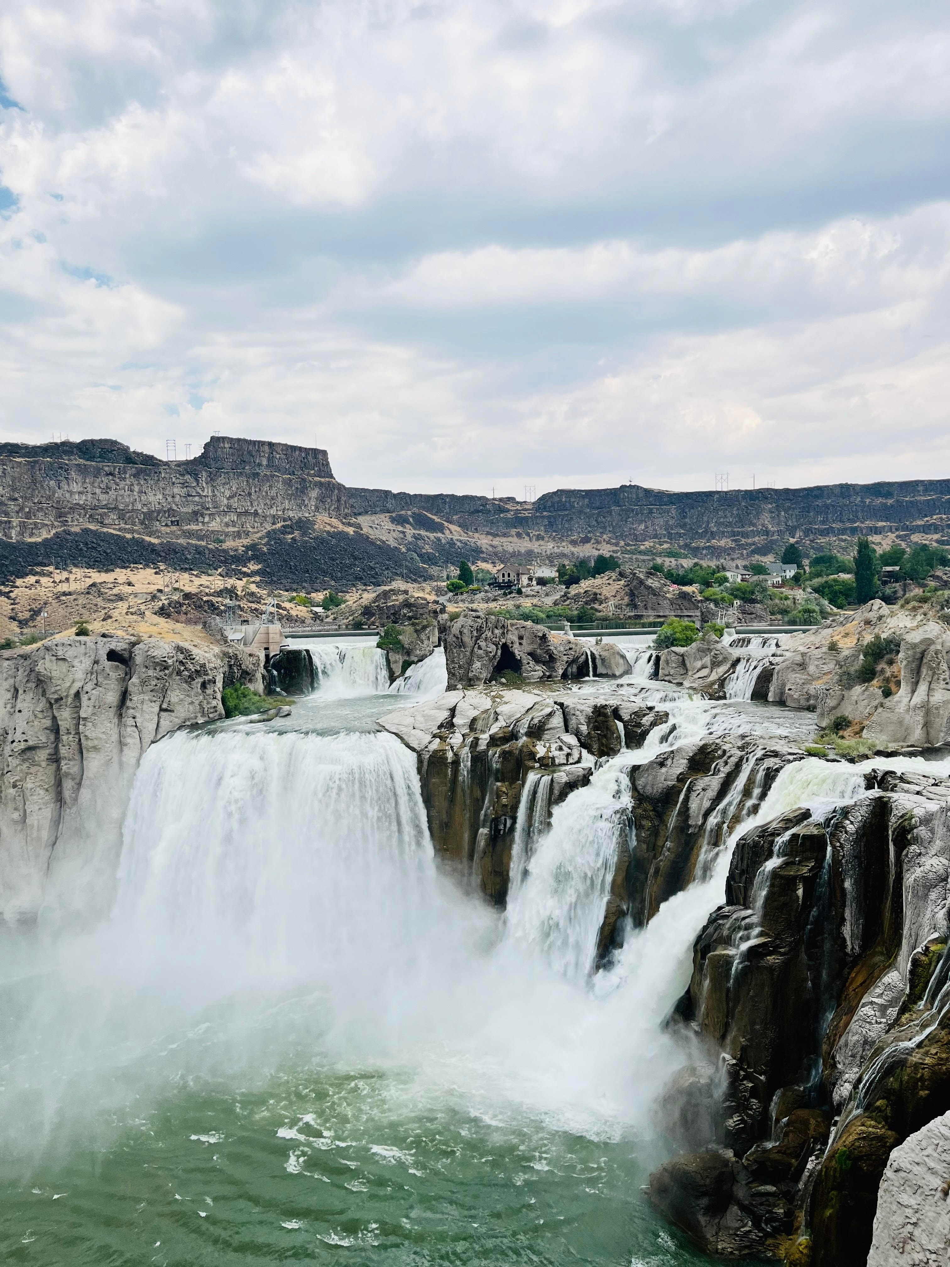 Aerial view of a large waterfall pouring from cliffs on a cloudy day