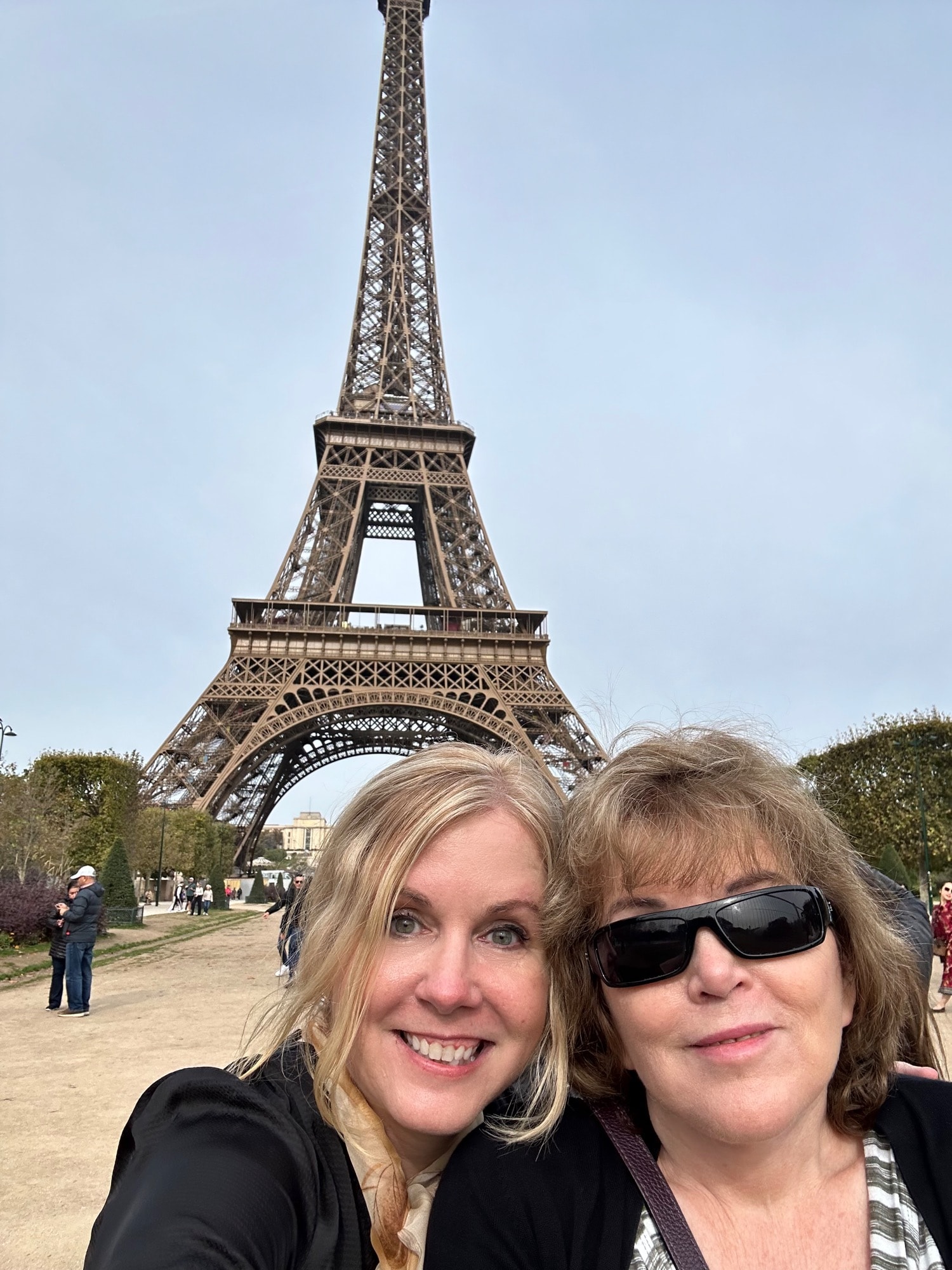 Advisor and friend taking a selfie in front of the Eiffel Tower on a cloudy day in Paris