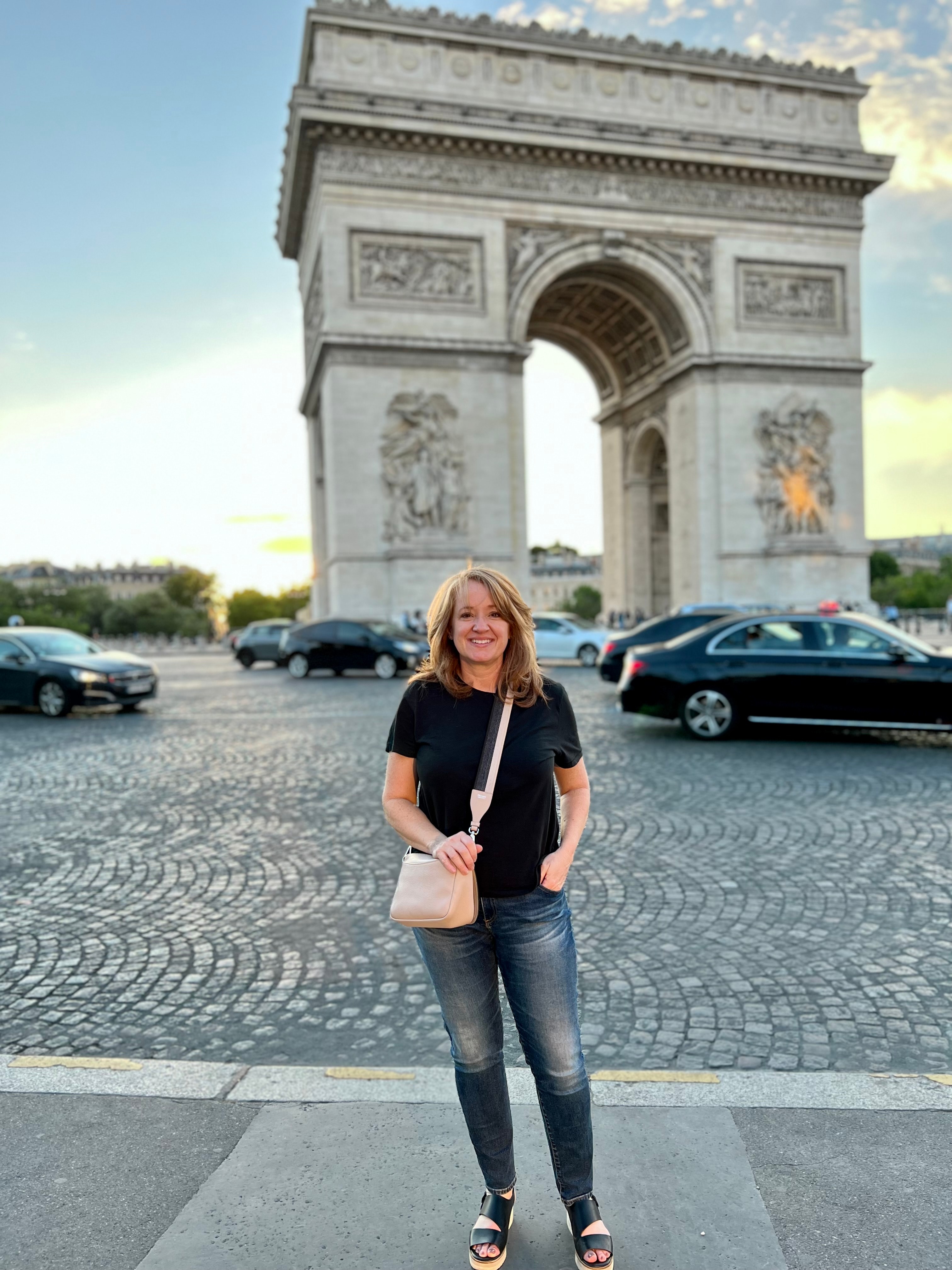 Advisor posing in front of the Champs-Élysées on a clear day at dusk. 