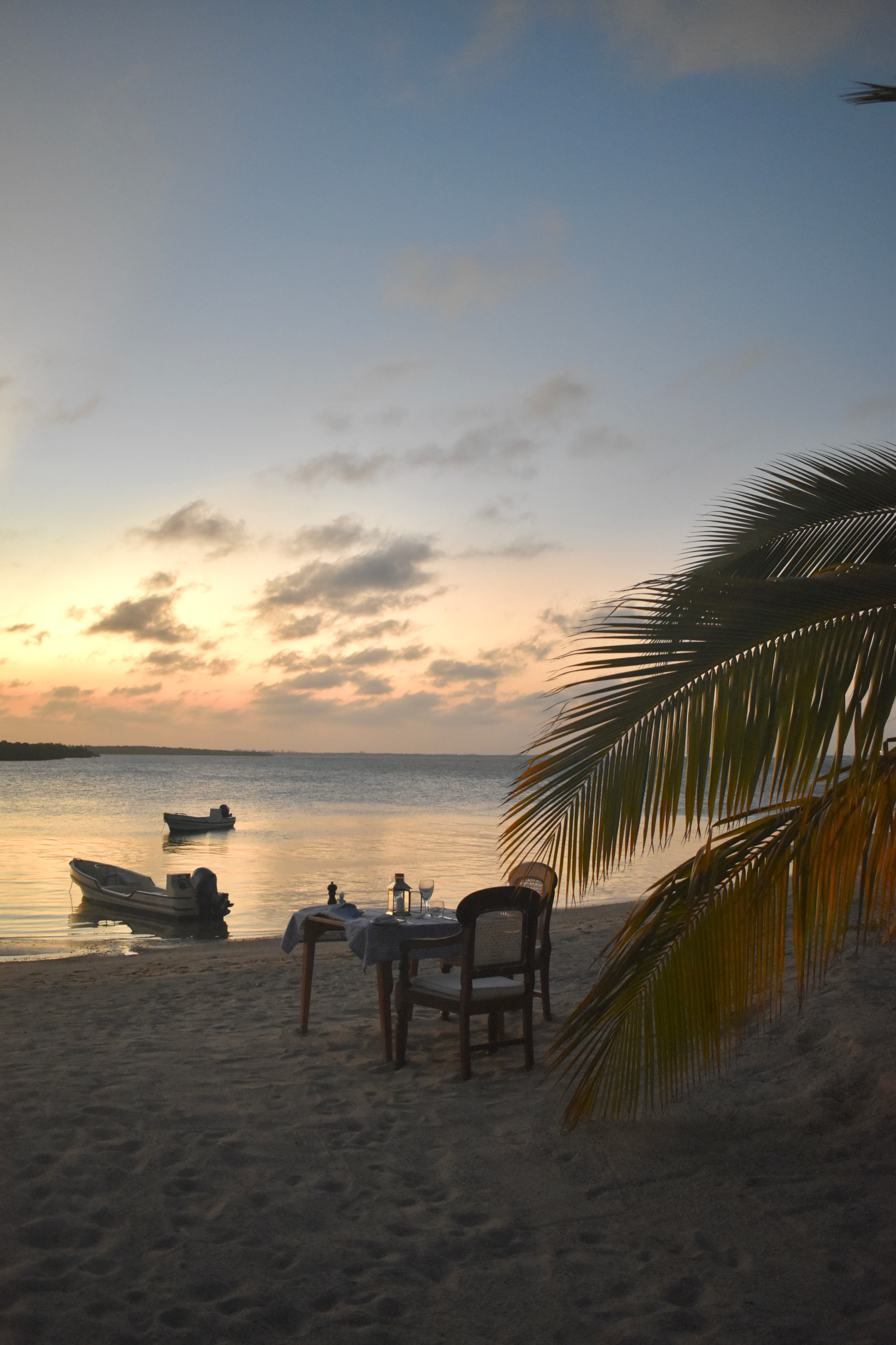 View of a singular table set on the beach at sunset