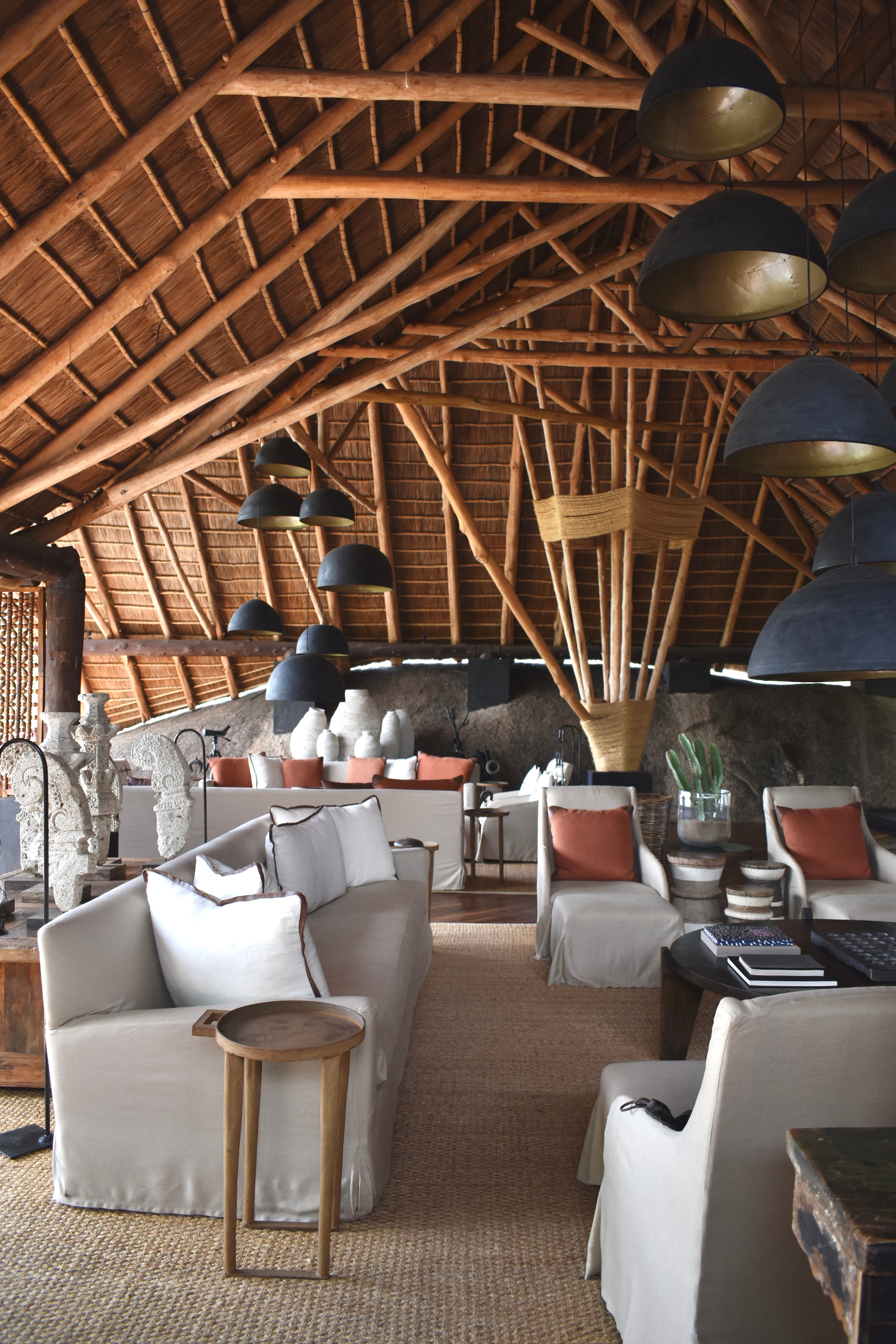 Interior view of a lobby area with grey and white furniture and a vaulted wooden ceiling