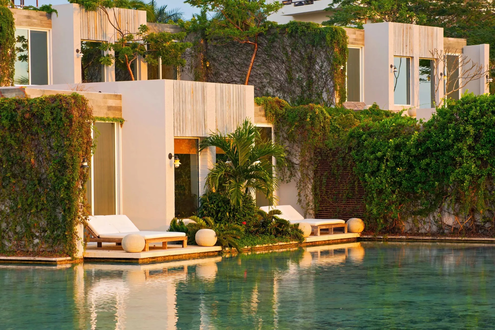 plush white loungers on a casita porch overlooking a plunge pool