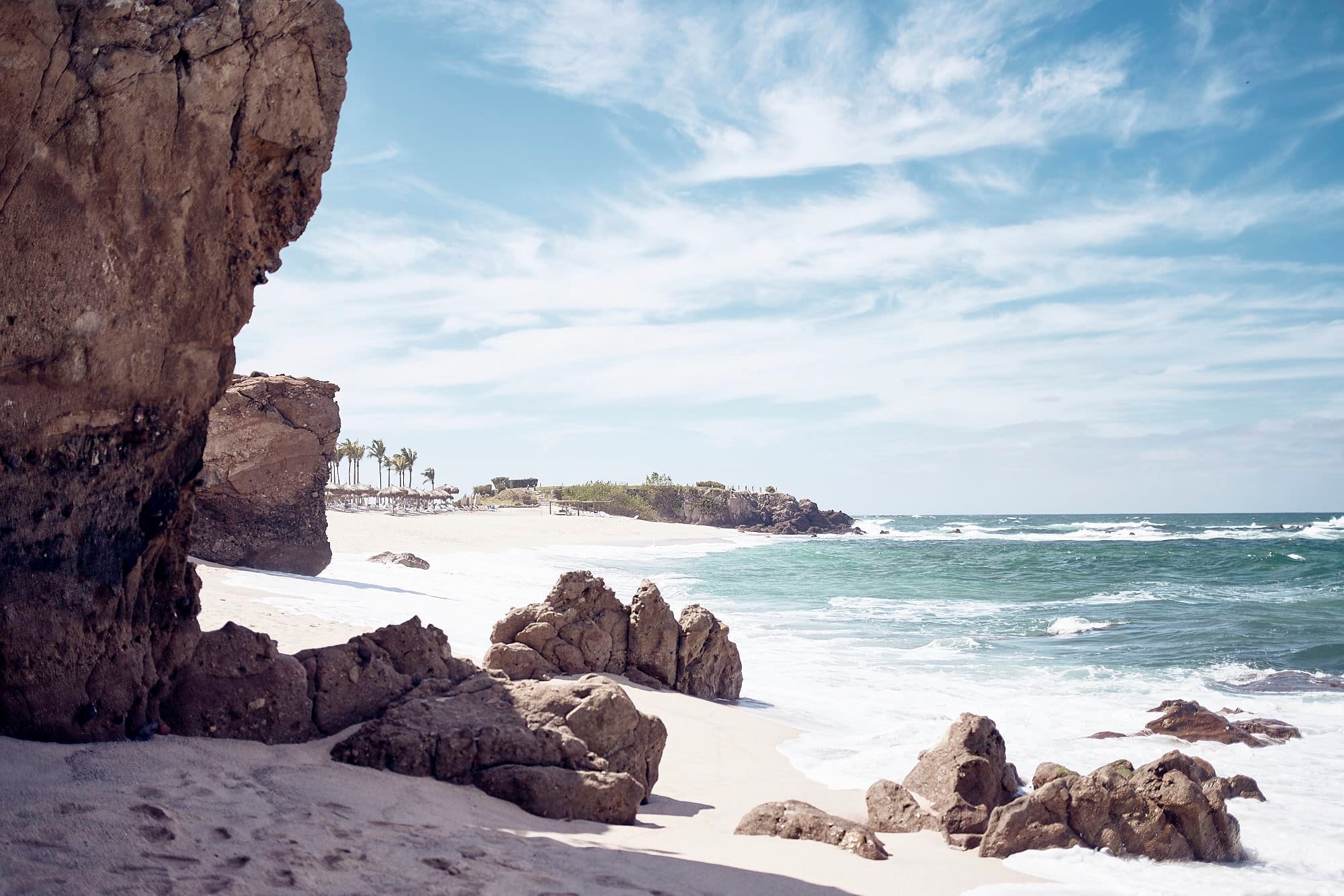 large rocks on a sunny white-sand beach