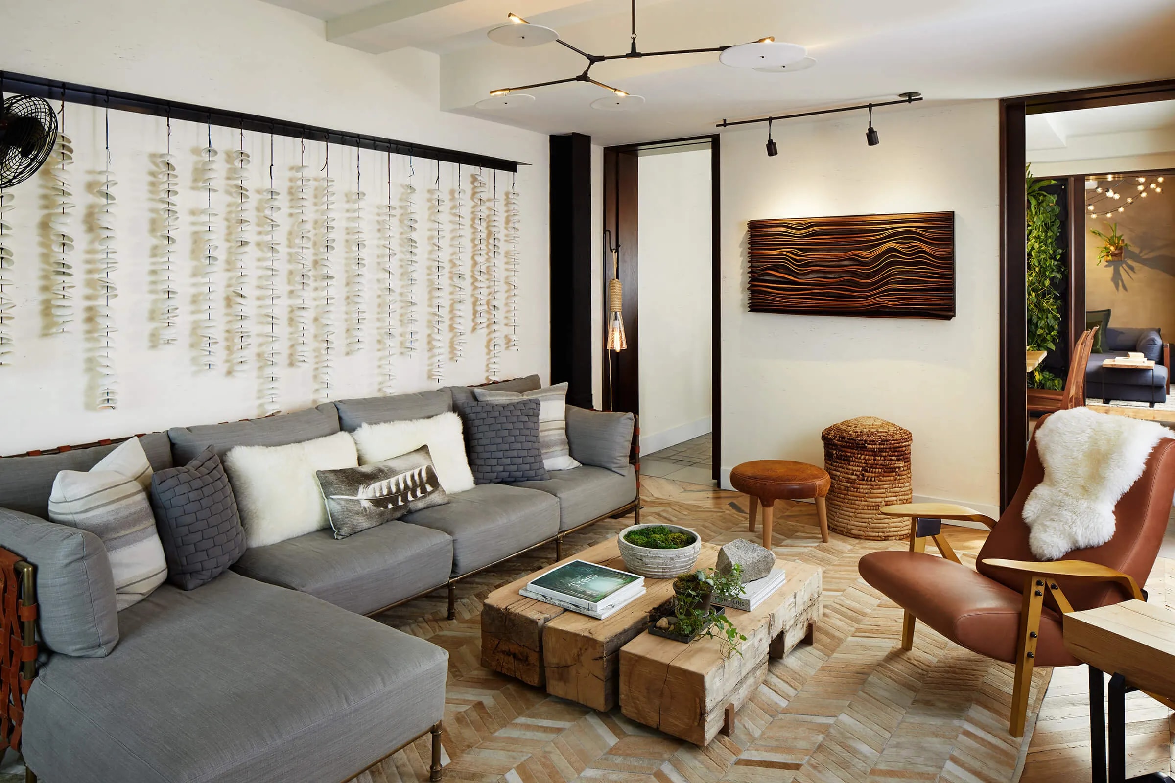 a luxe hotel living room with a leather chair and a gray L-shaped couch