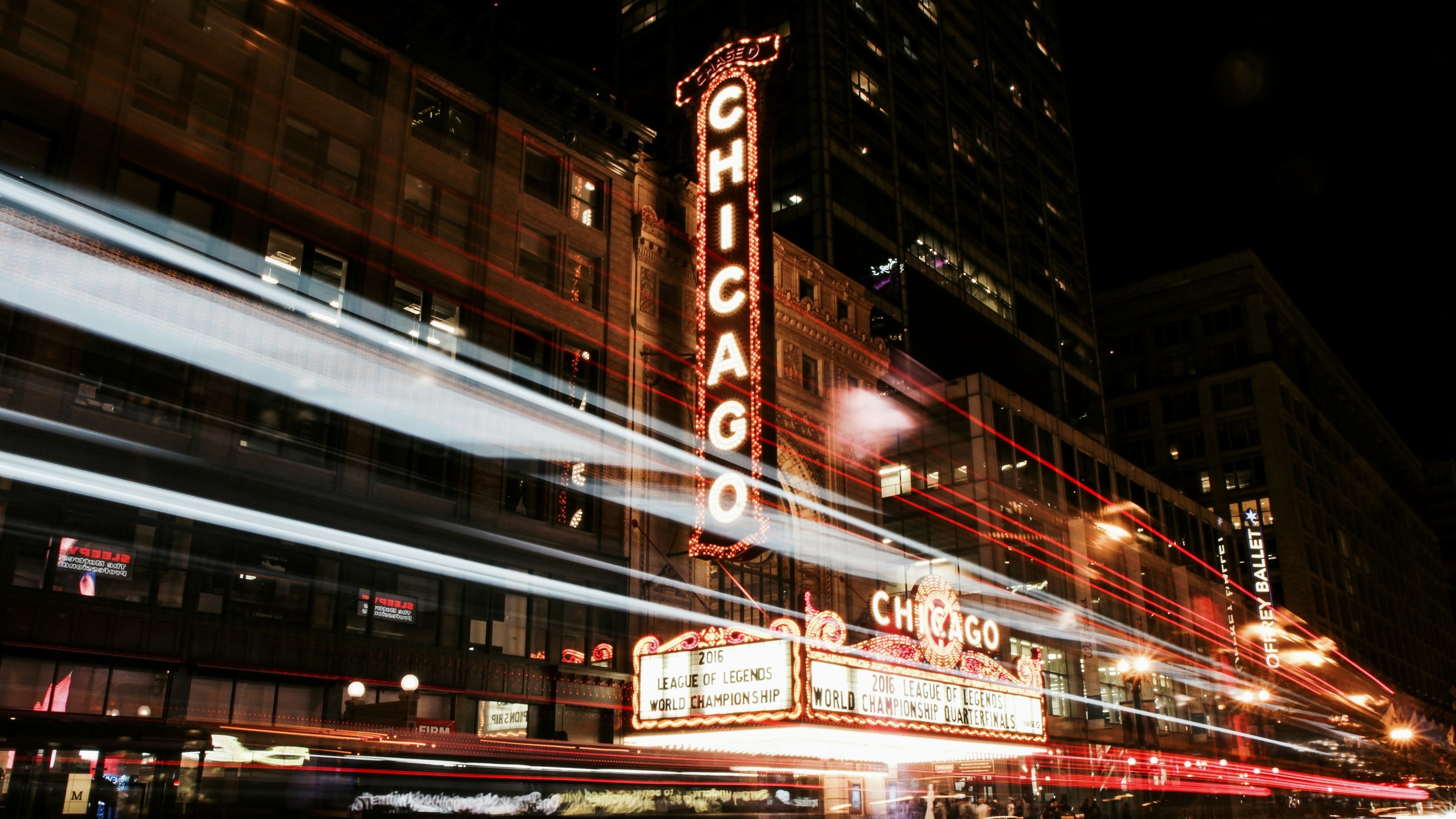 A time-lapse photo of the Chicago Theater at night.