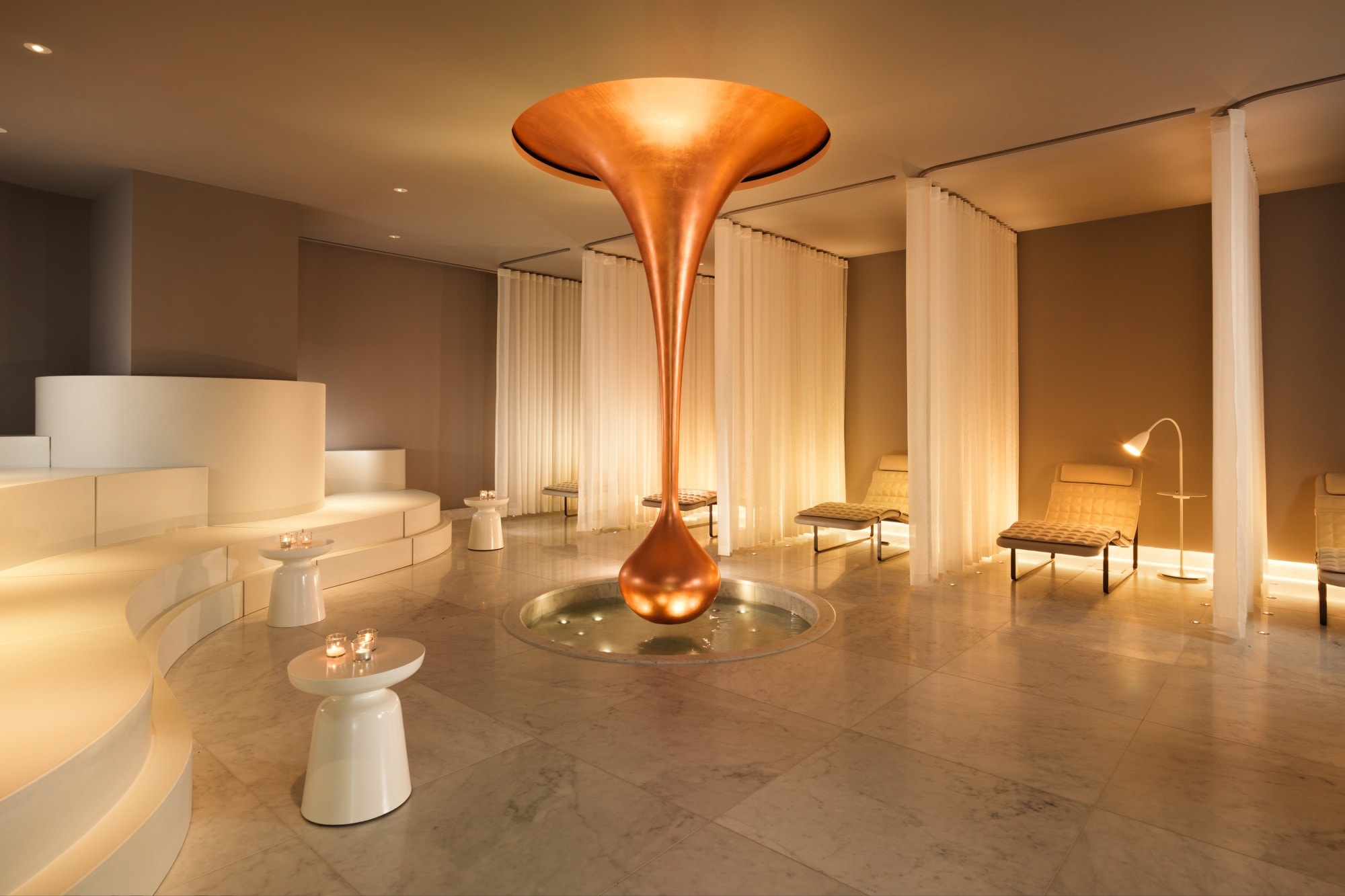 an airy spa with a copper-colored sculpture hanging from the ceiling