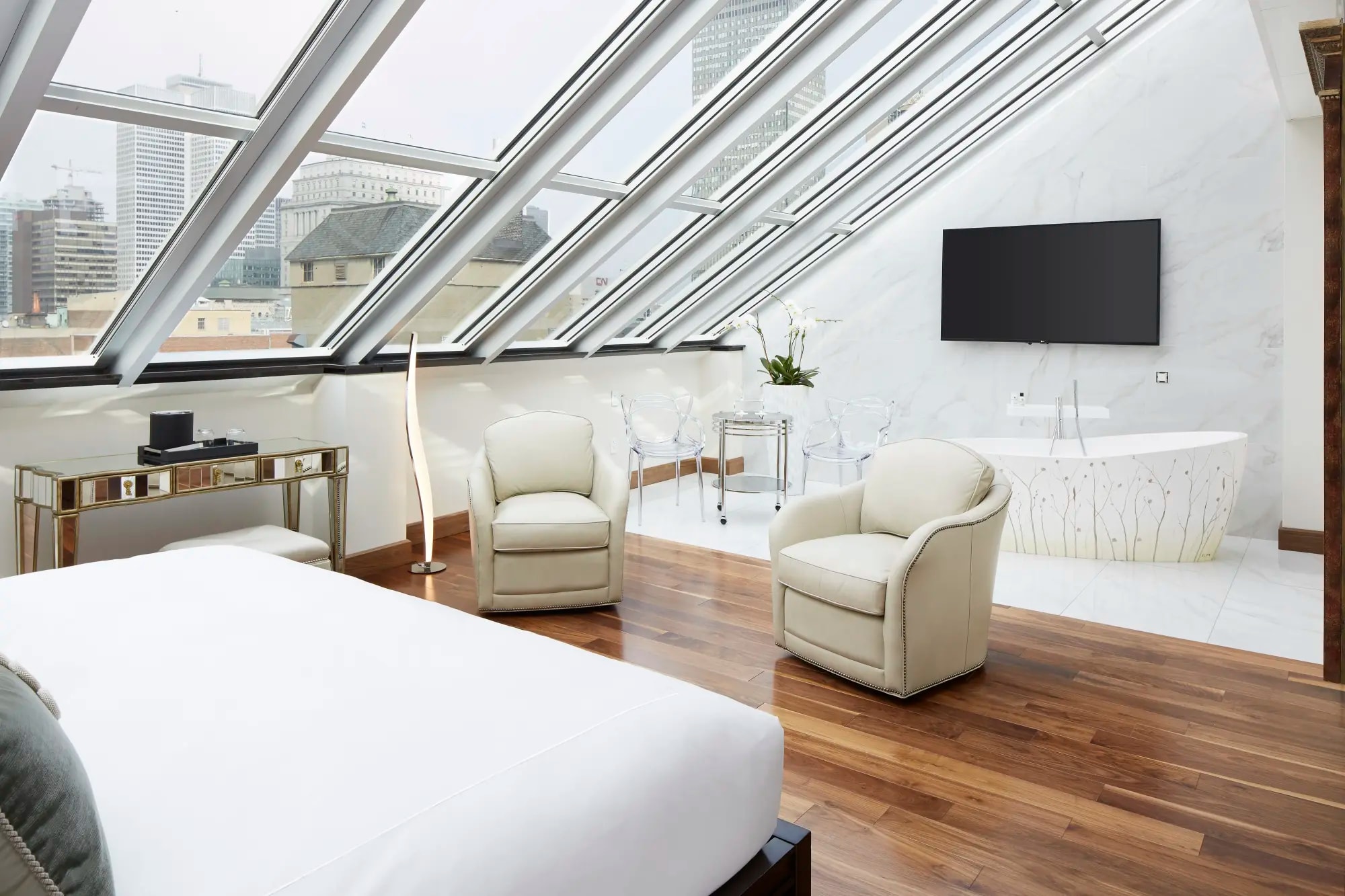 a whitewashed bedroom under a slanted glass roof