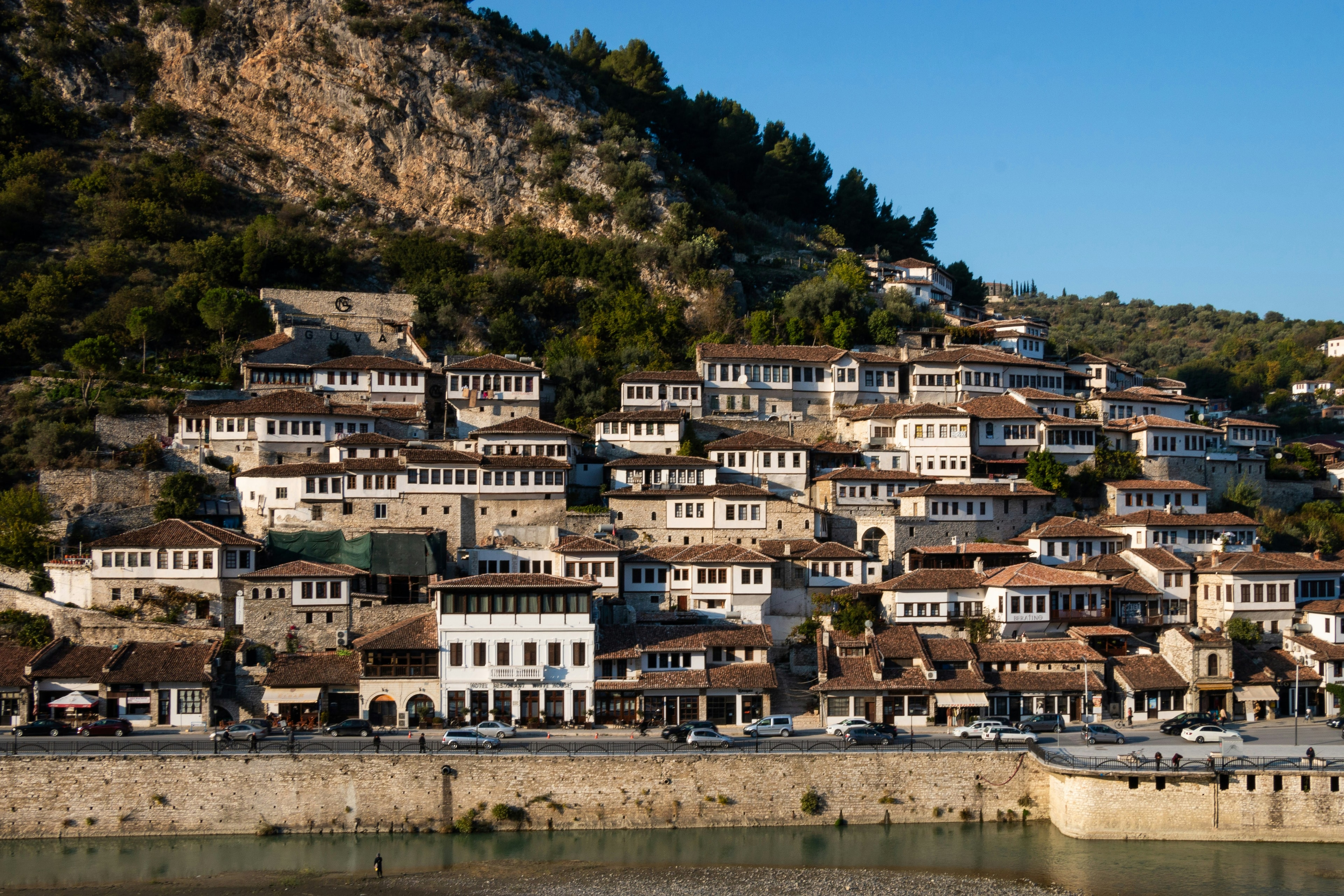 White Ottoman houses at Berat, a UNESCO World Heritage site, line the hillside coast on a clear day. 