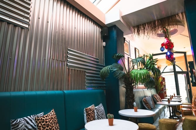 Chic restaurant interior with table and chairs on a sunny day.