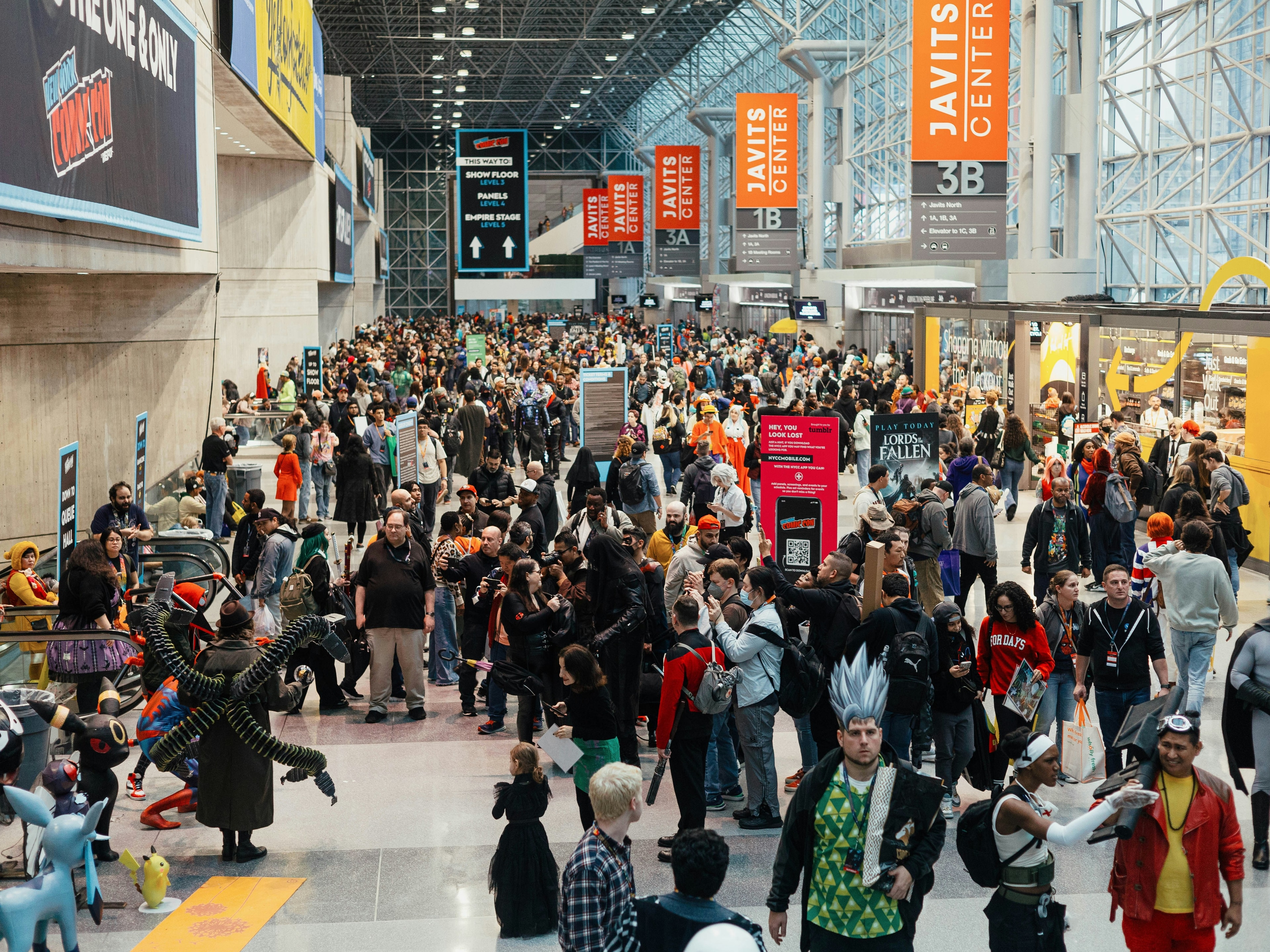 a-large-group-of-people-walking-through-an-arena-NYC-travel-guide