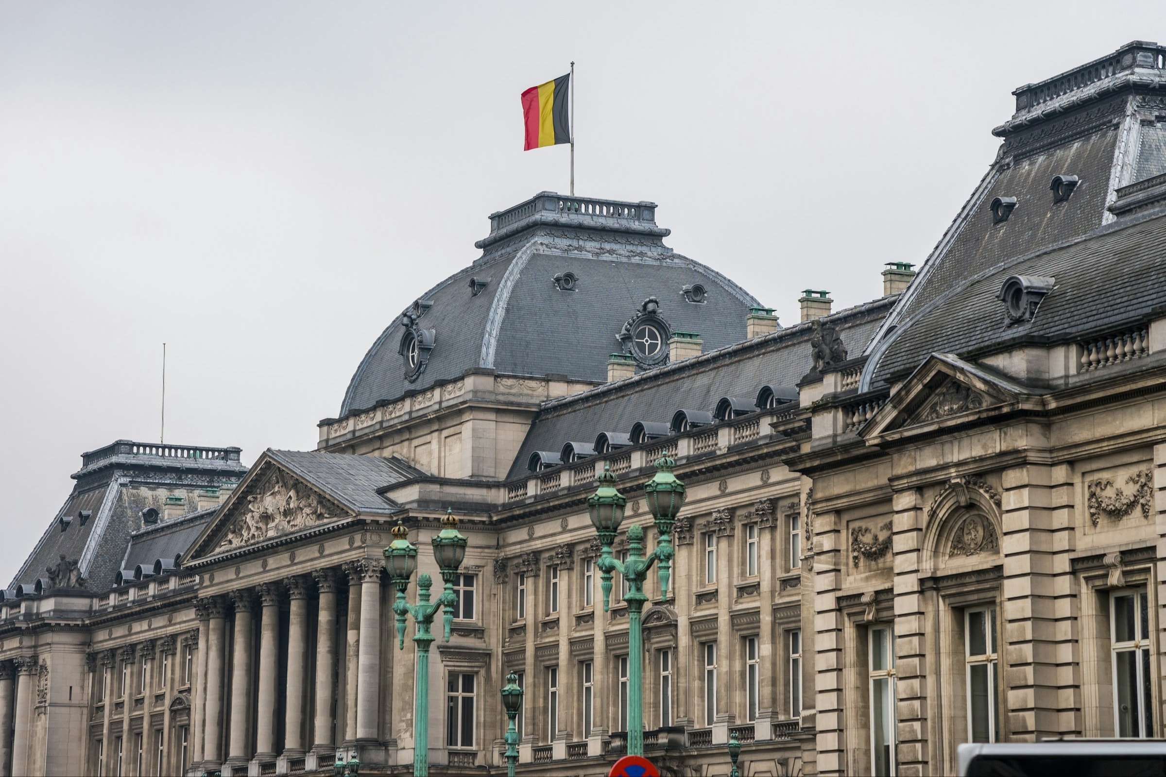 The Belgian flag is perched above the Royal Palace of Brussels.