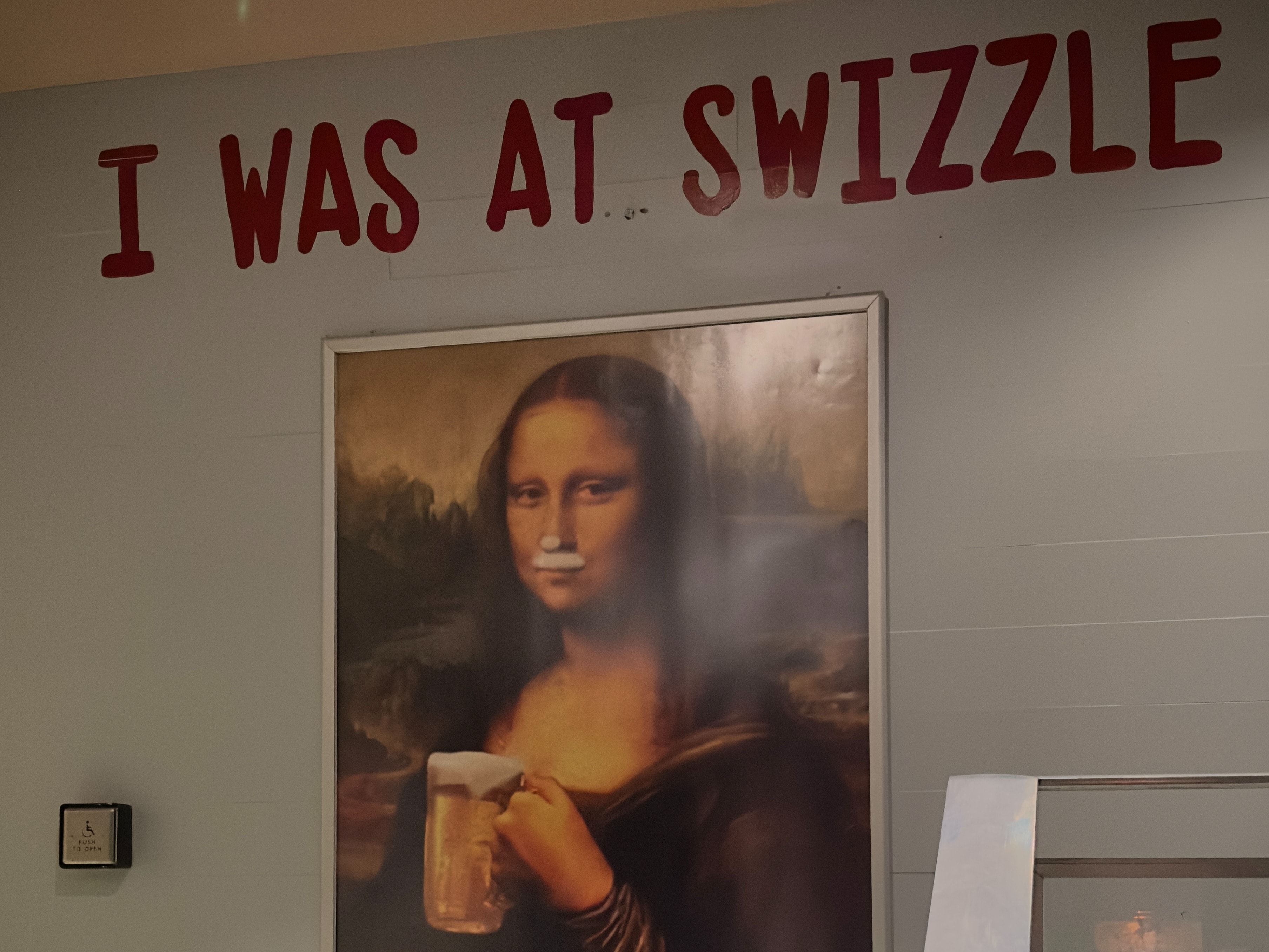 The image features a modified artwork of “Mona Lisa” holding a beverage, with the text “I WAS AT SWIZZLE” and a censor bar over the face.