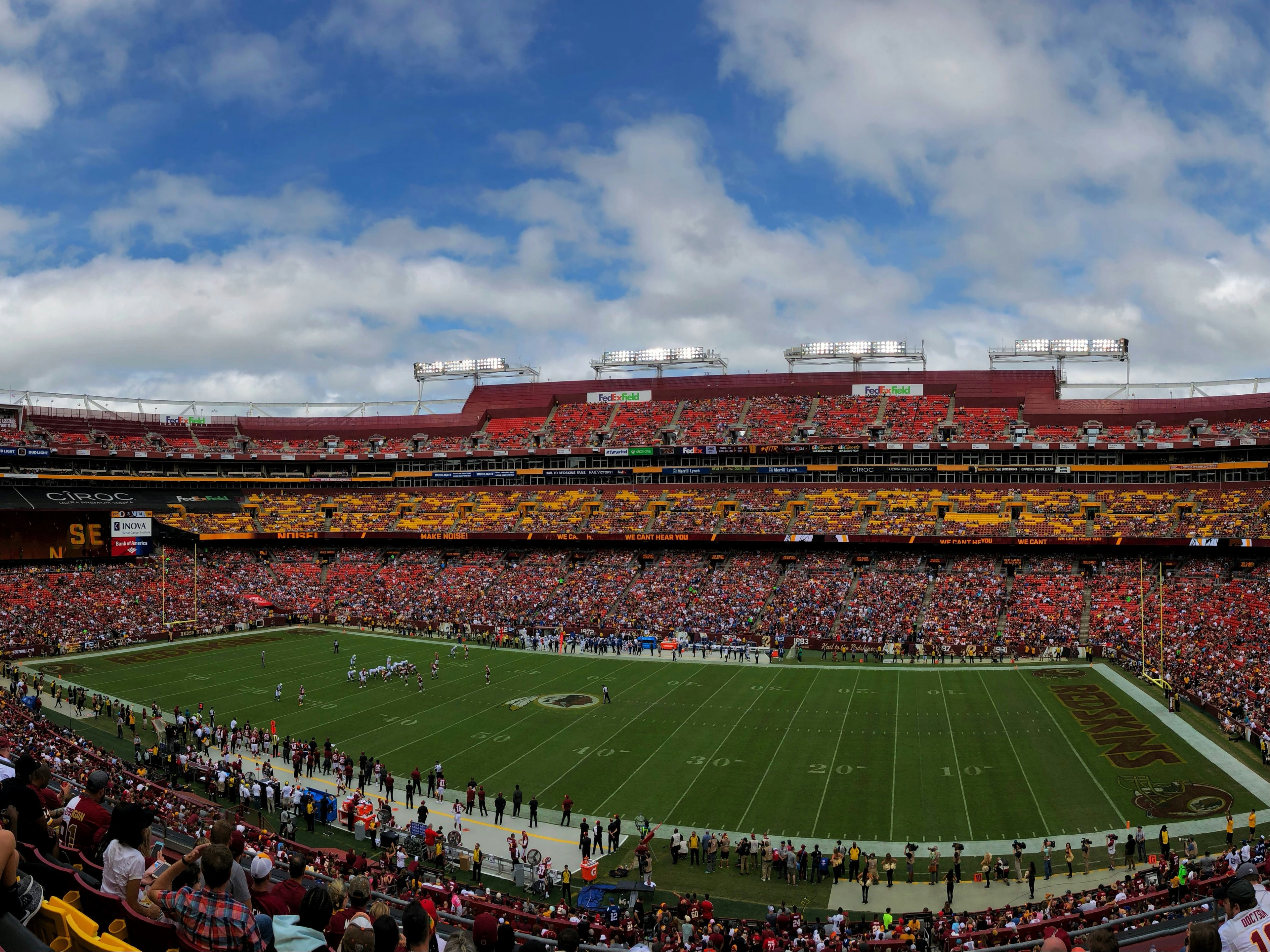 A panoramic view of a bustling football stadium during a daytime match.