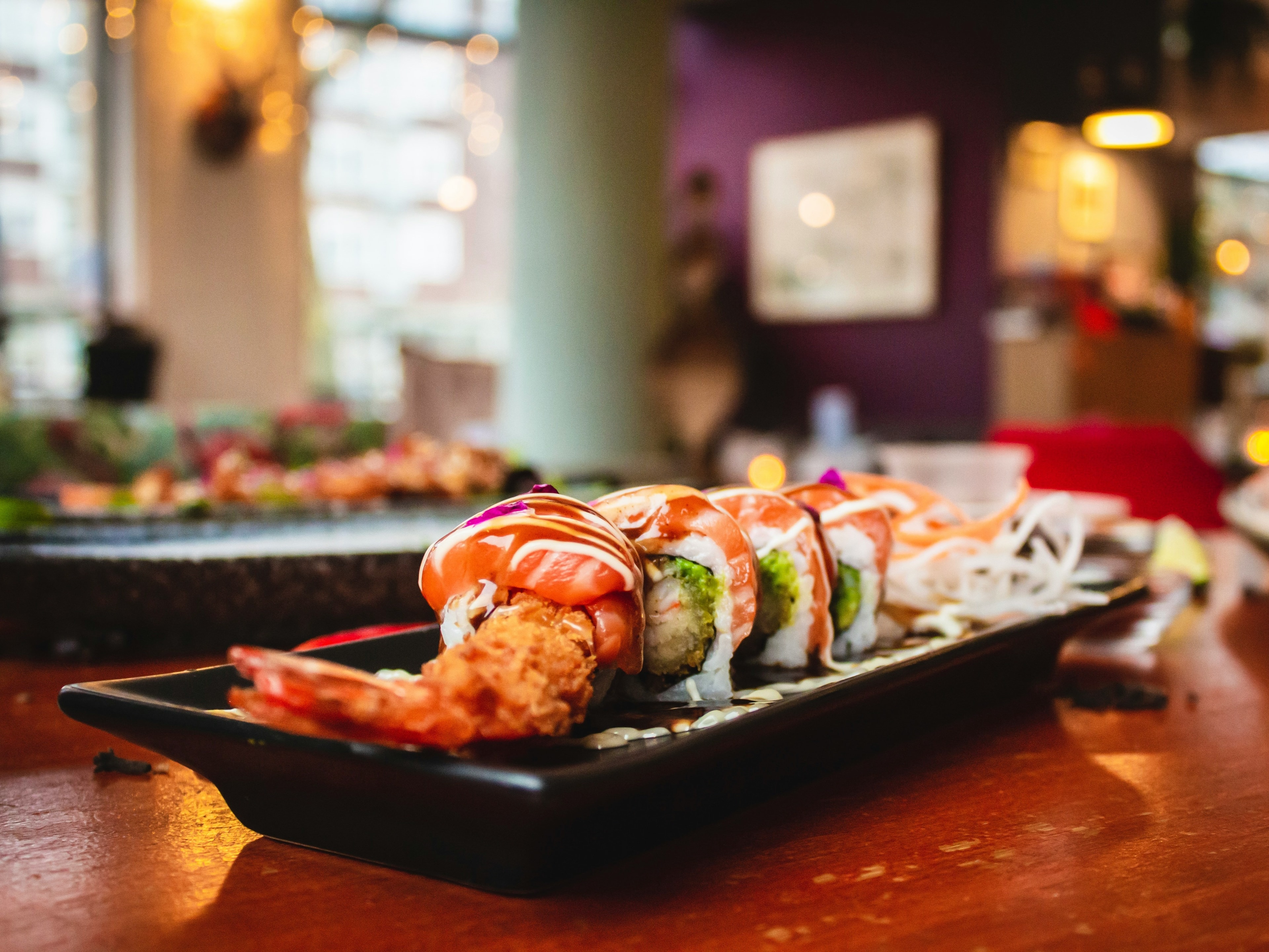 The image showcases a sushi platter with various toppings in a restaurant setting, ready to be enjoyed.