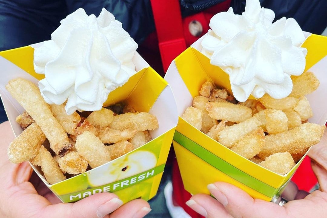 Apple fries in paper cartons topped with whipped cream at Granny's Apple Fries.