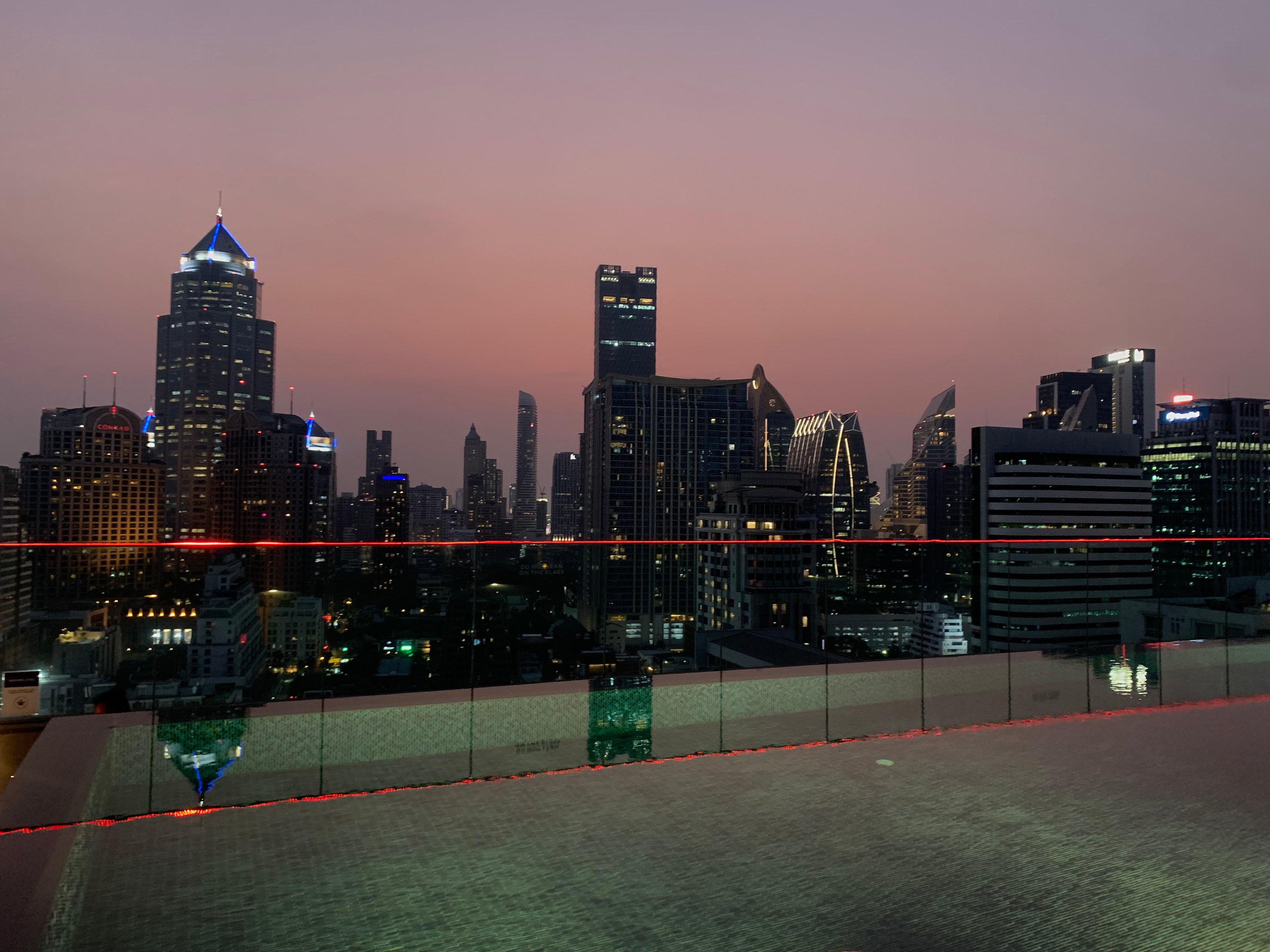 View from a rooftop of high rise city buildings lit up at night