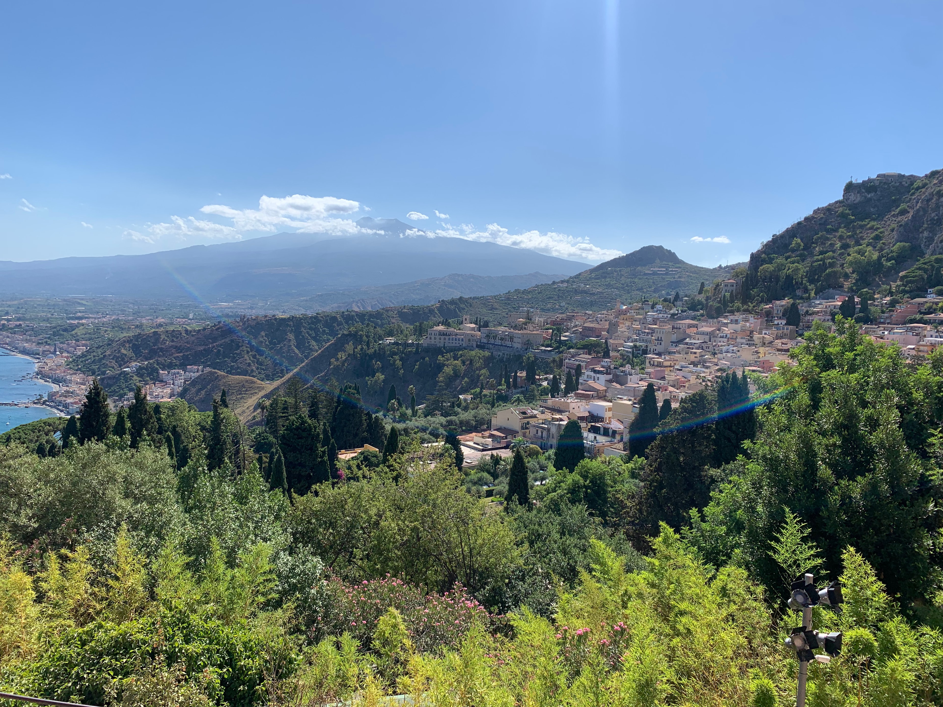 Beautiful view of a coastal city surrounded y nature with mountains in the distance