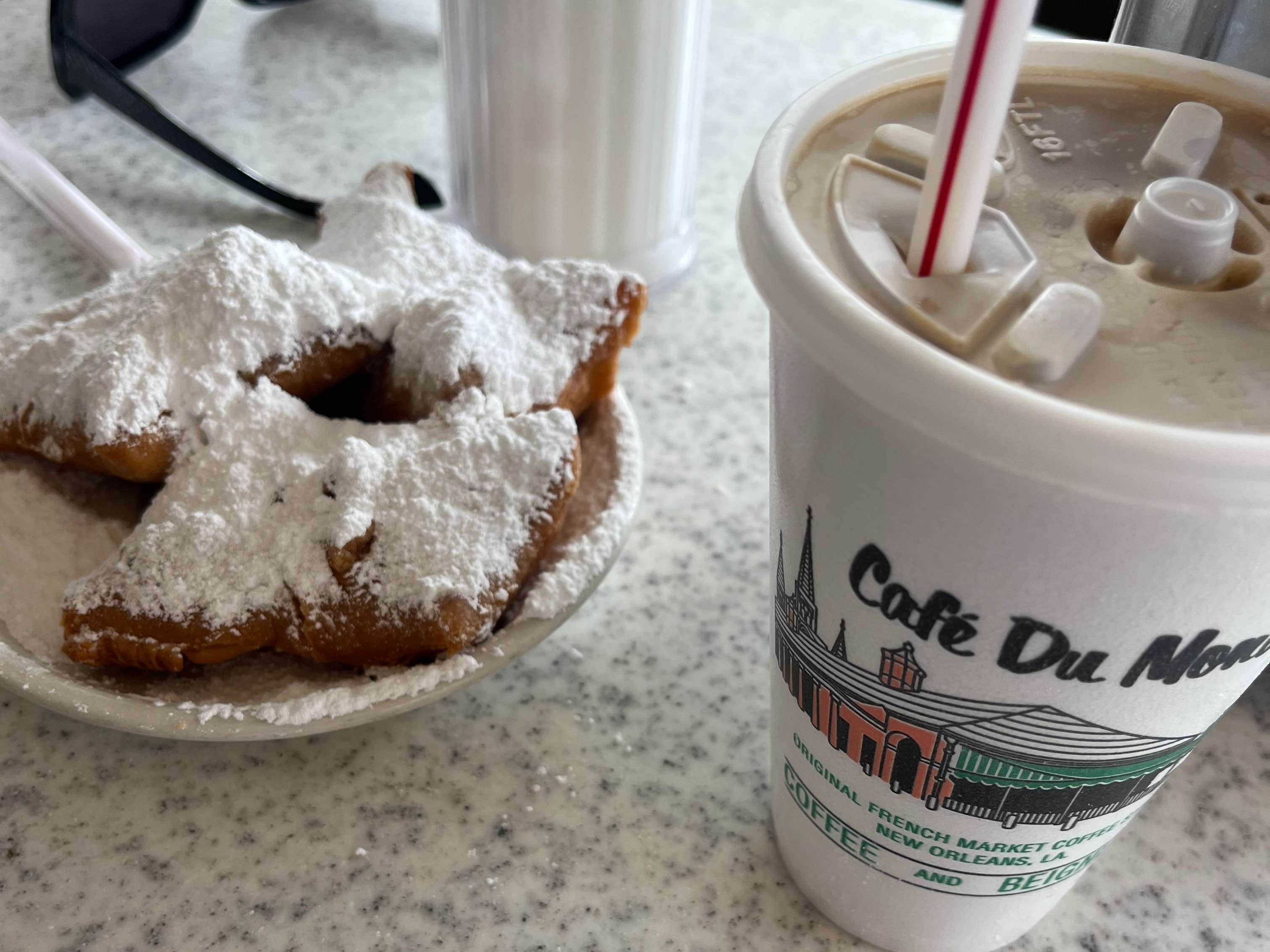 Beignets and coffee on a table at Cafe du Monde.