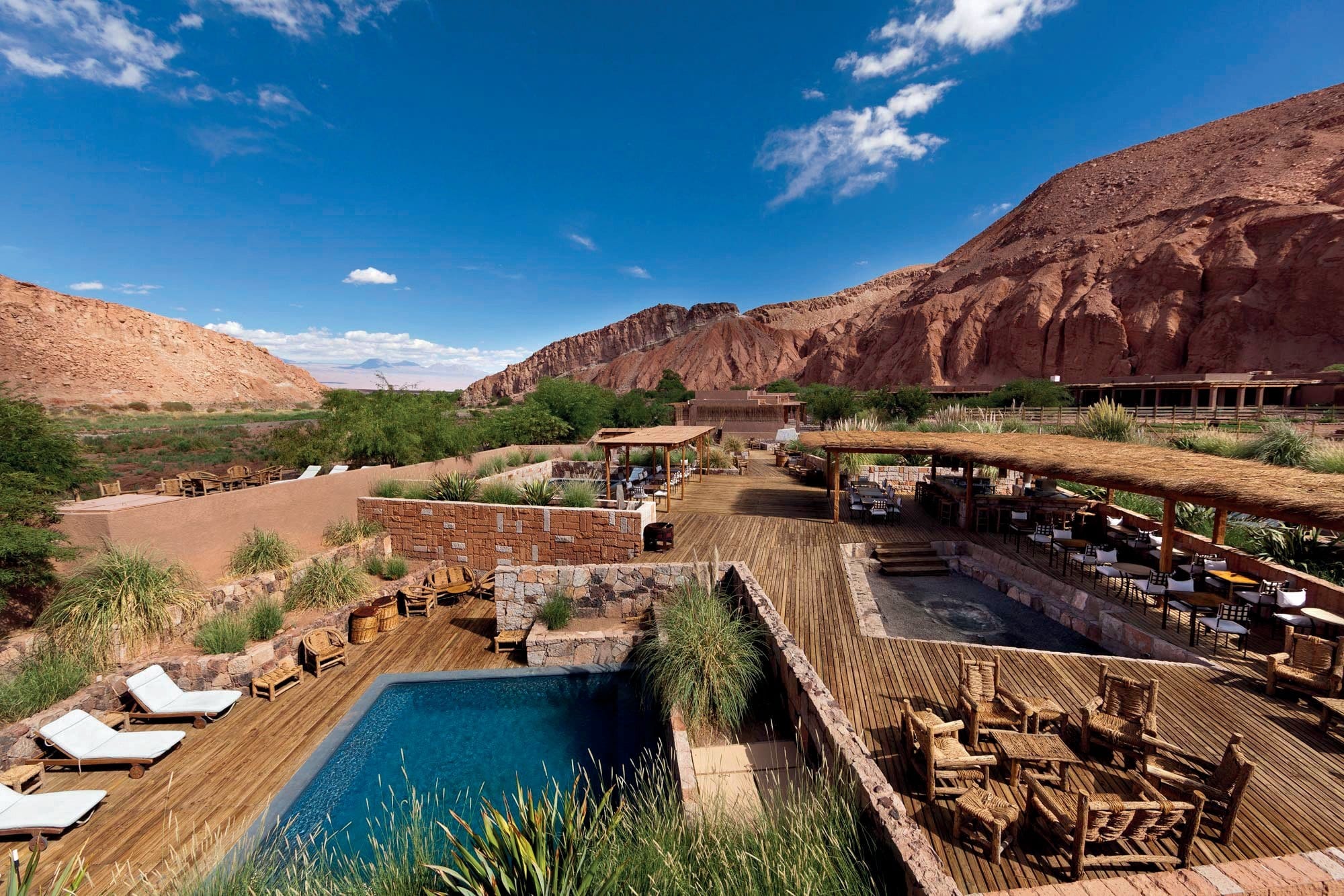 a luxe desert hotel compound with an outdoor pool near red-rock mesas