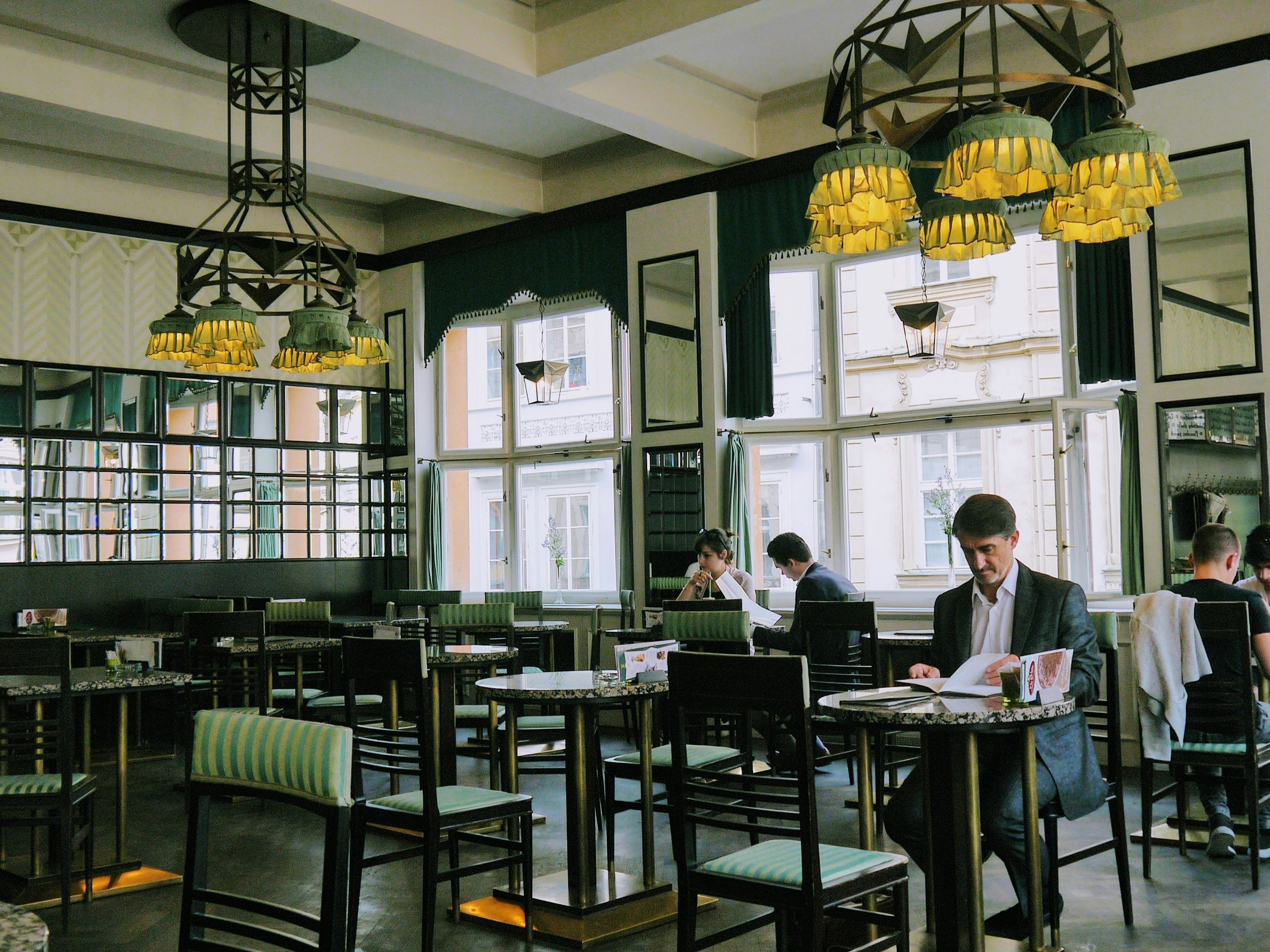 A picture of people sitting inside a restaurant during the daytime.