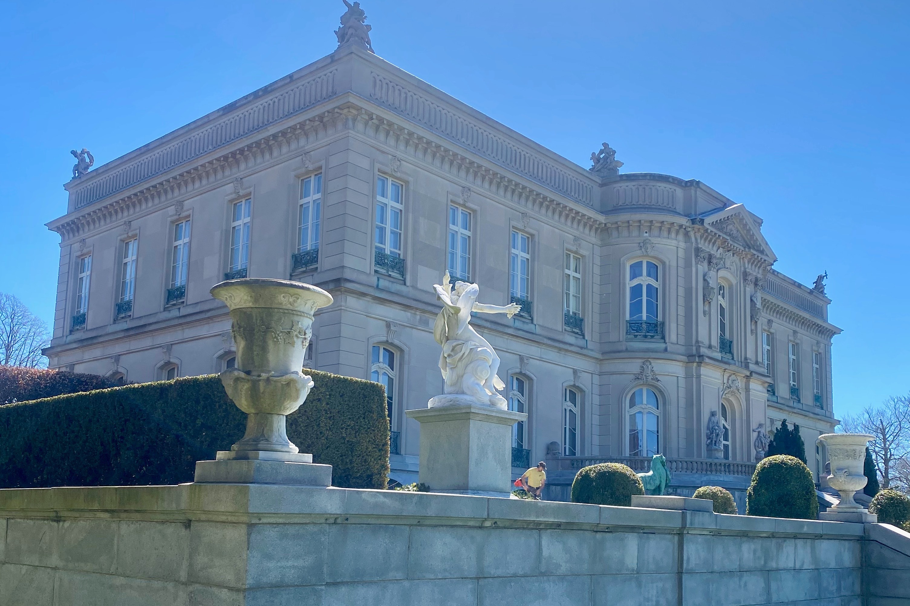 The outside of a large mansion during the daytime