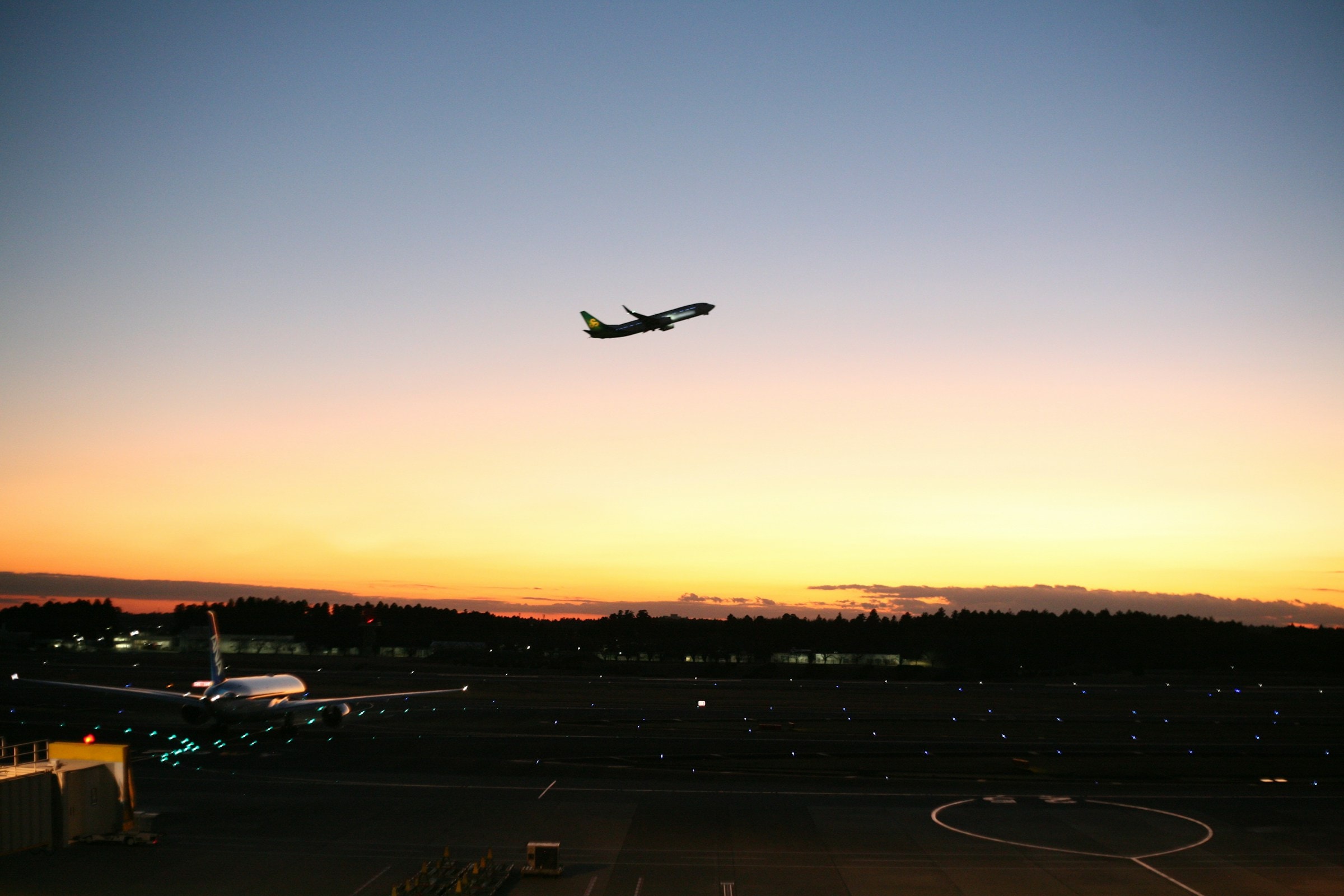 An airplane in the sky during a sunrise