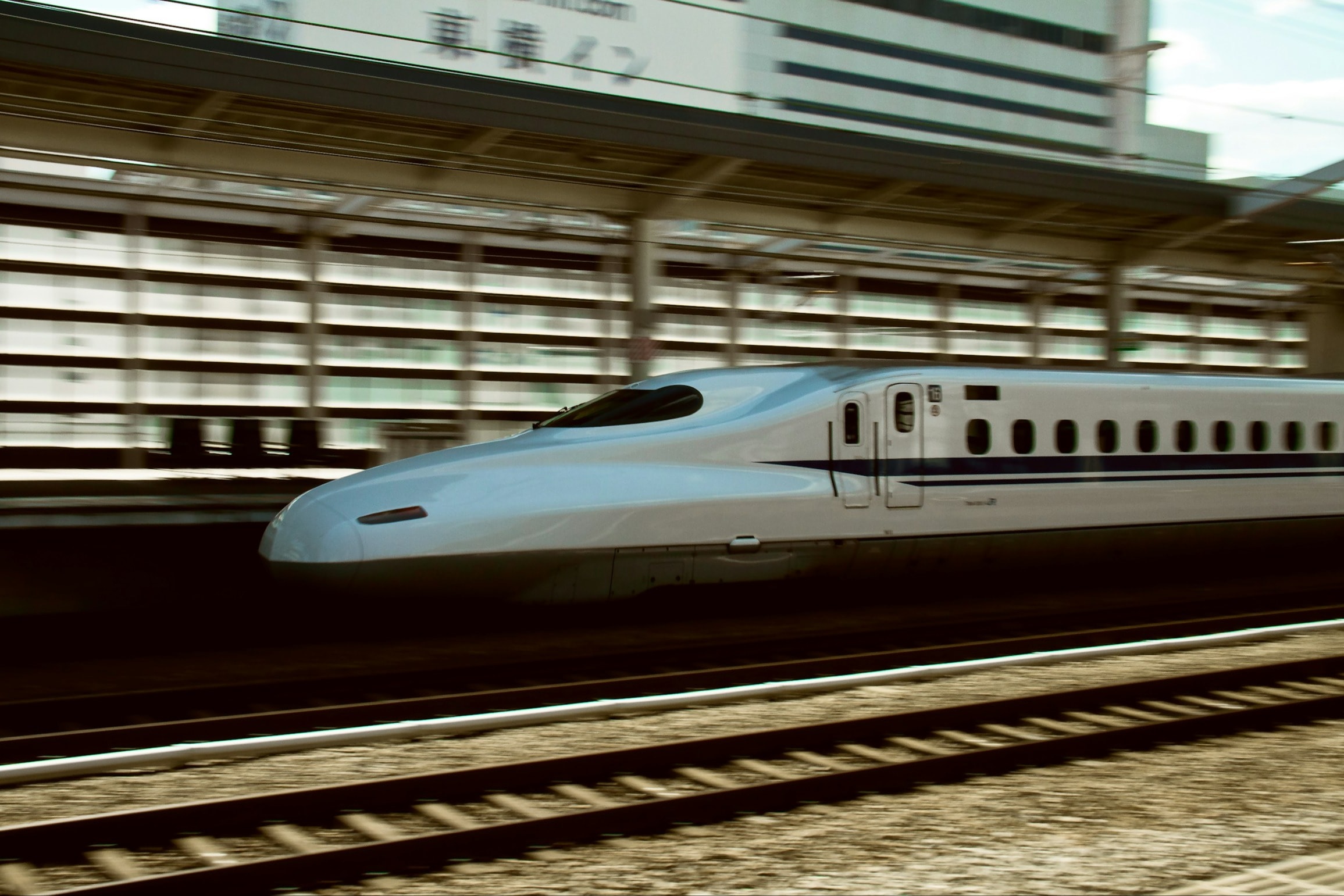 A bullet train moving through a train station