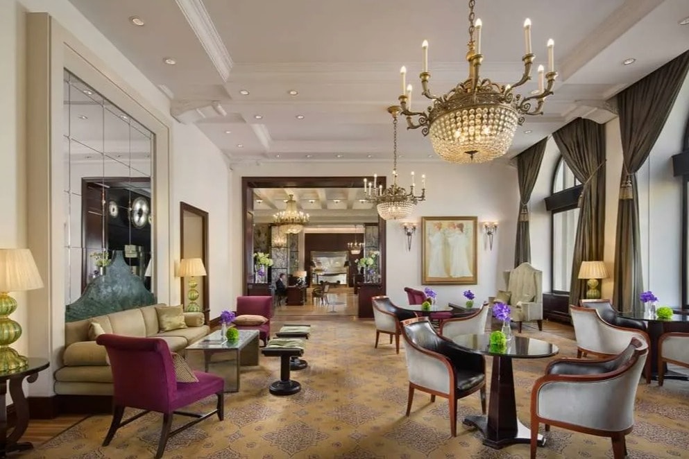 fancy hotel lobby with chandeliers and velvet seating