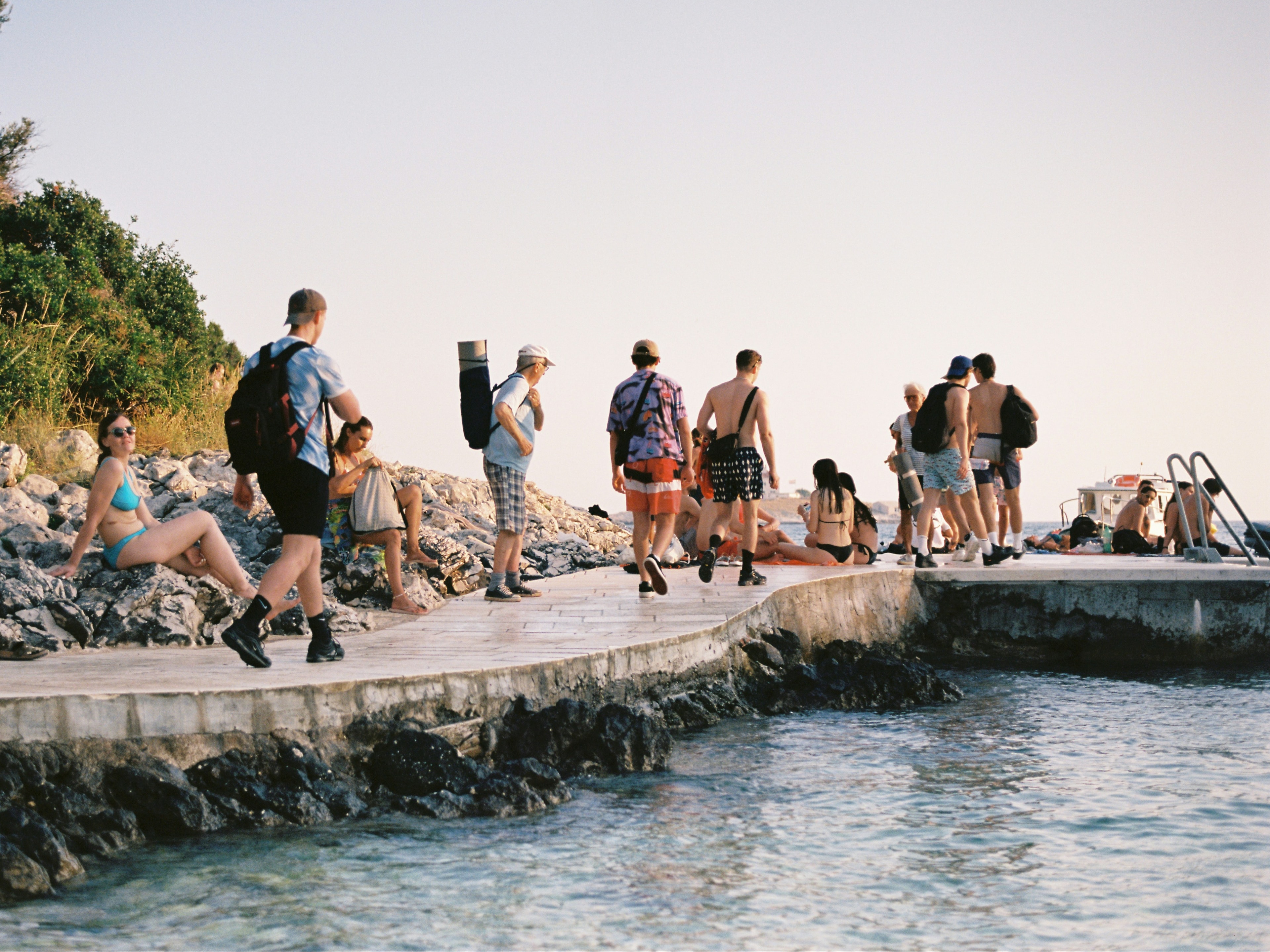 People standing on a stone pier during the daytime.