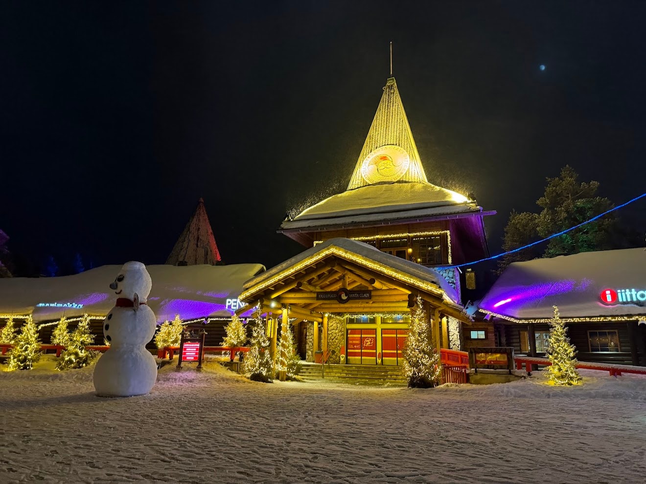 A photo of a restaurant, designed as a wooden cabin, covered in snow on a winter's day.