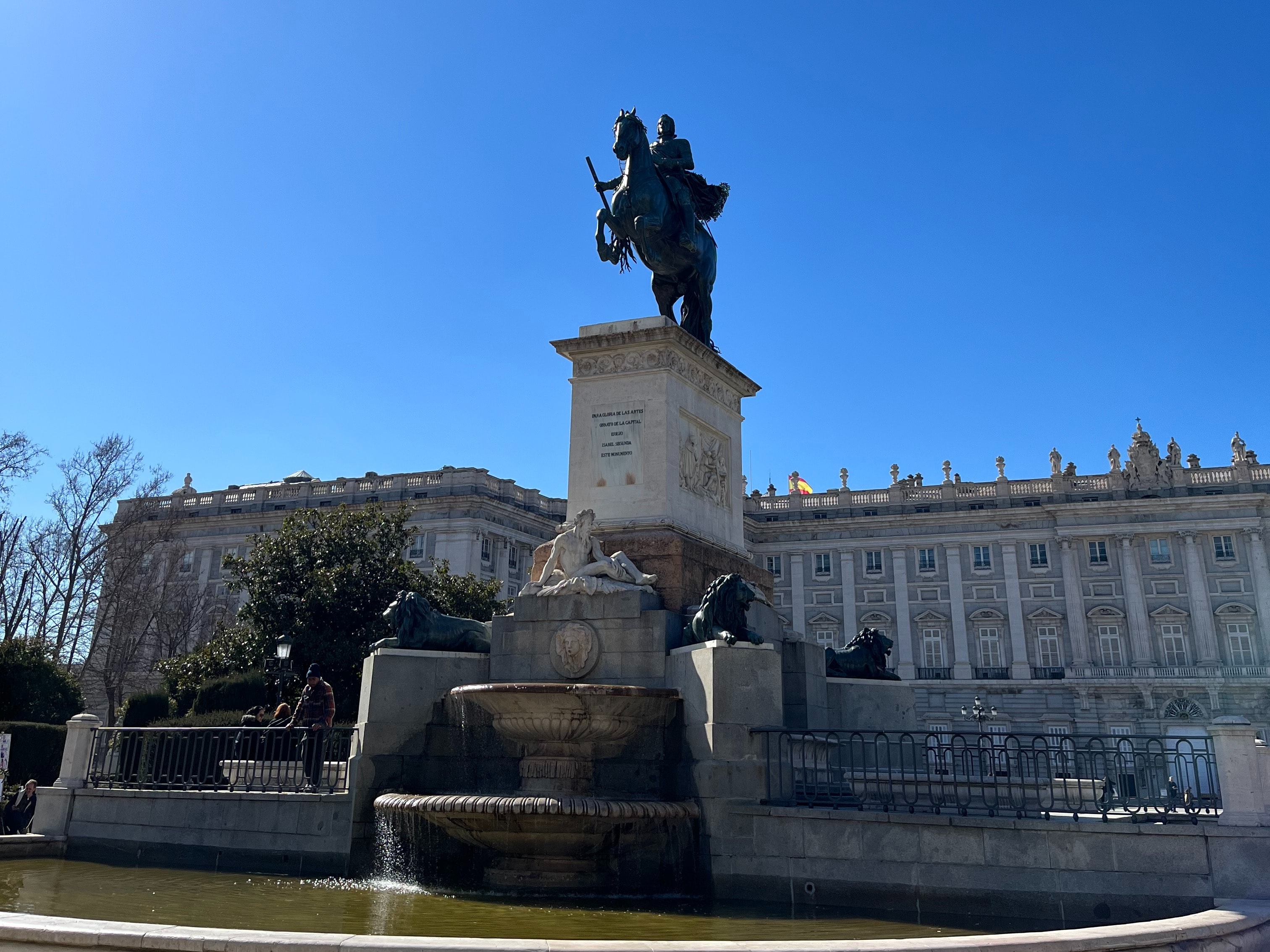 A majestic statue of a historical figure on horseback, set against a backdrop of classical architecture and blue skies.