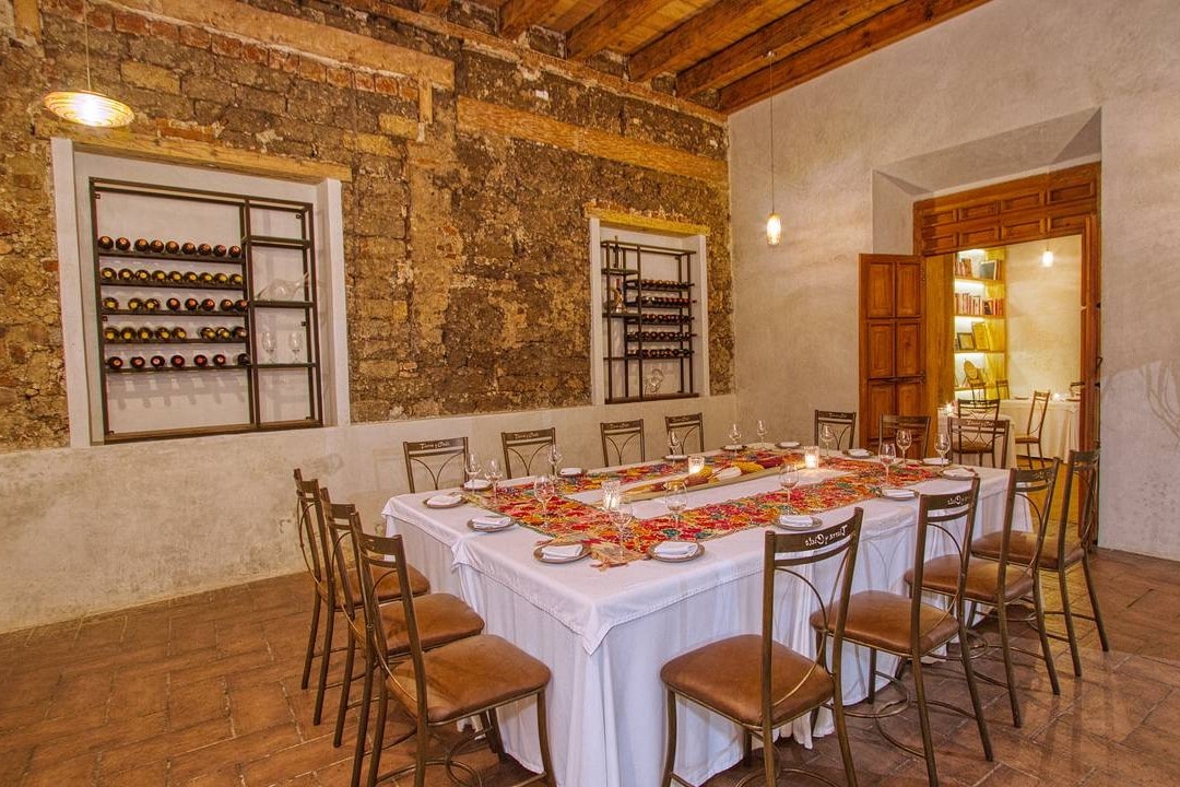 Tierra y Cielo Restaurante's elegant yet rustic dining area with a large, rectangular table set for fifteen diners.