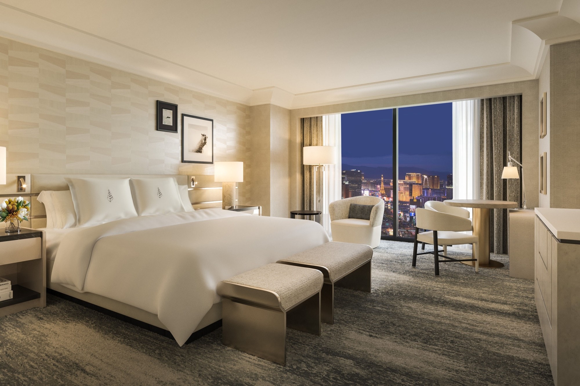 an elegant hotel room with a large white bed and views of an illuminated city at night