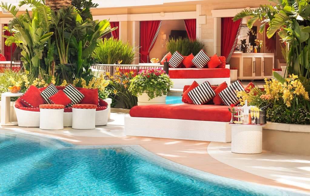 posh red furniture near a pool on a sunny day