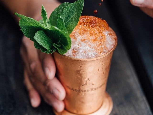 A frozen drink in a copper cup with a mint leaf on top